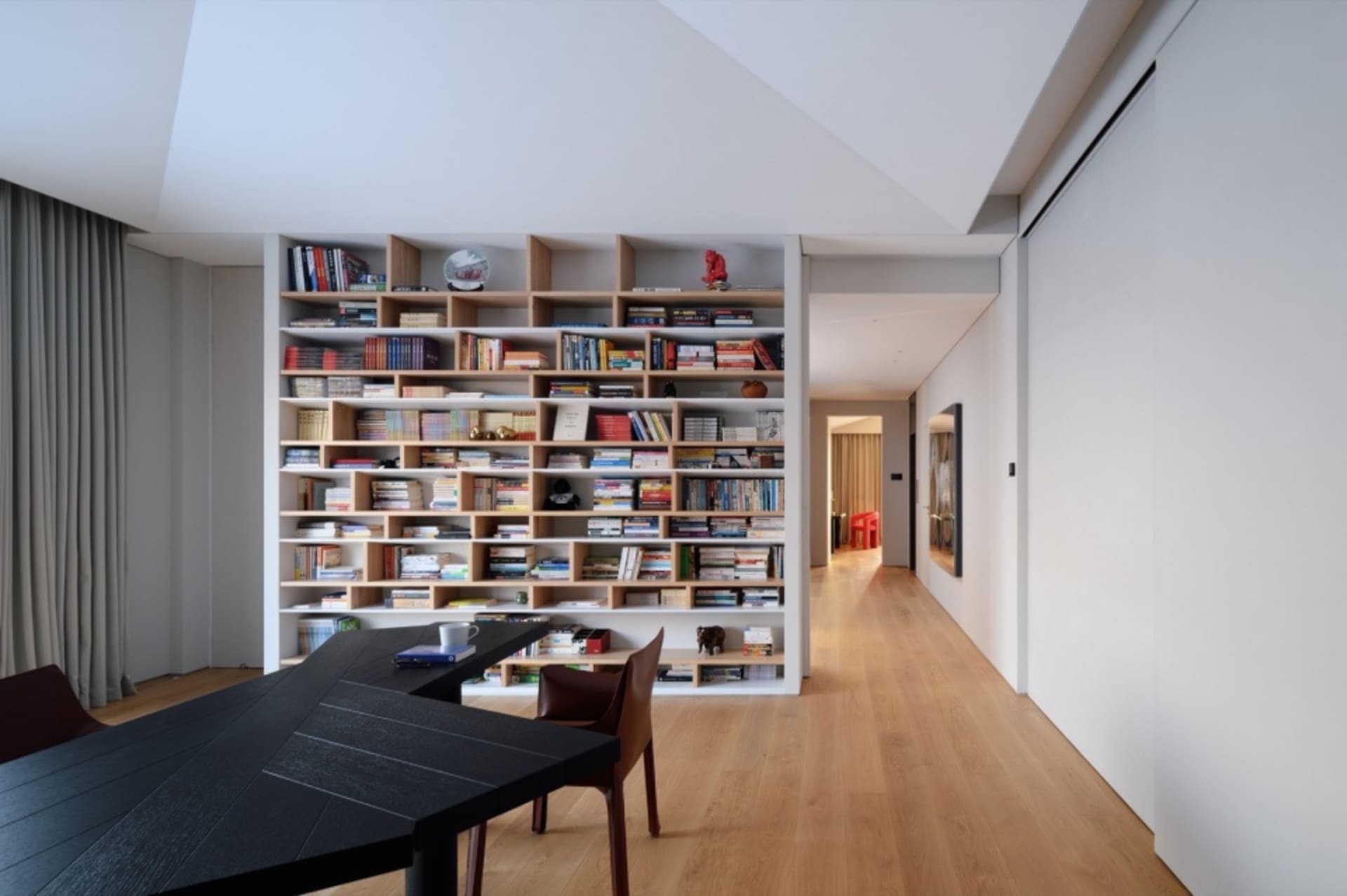 A modern library with wooden shelves filled with books.