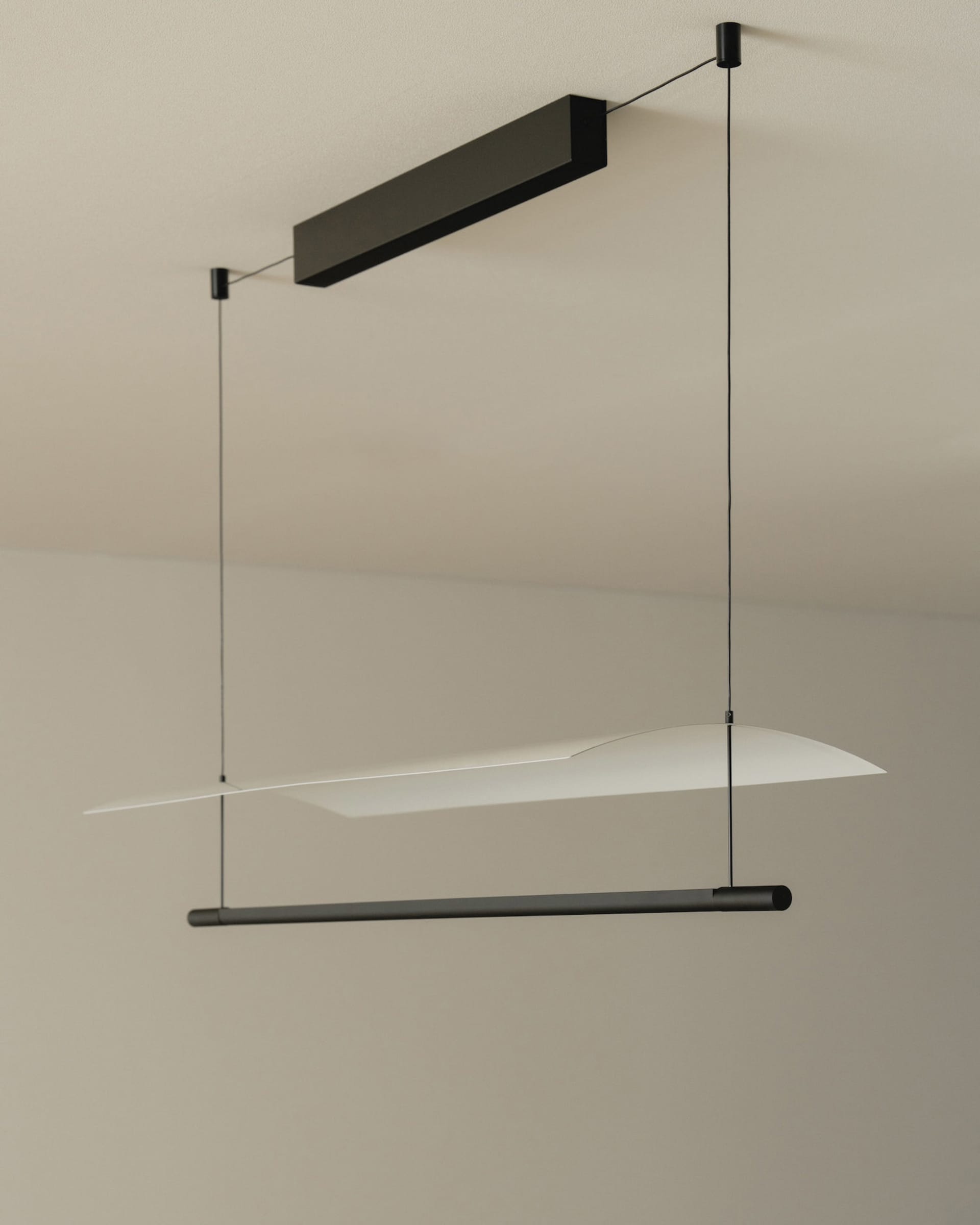 Black metal suspended lighting fixture with simple geometric shapes