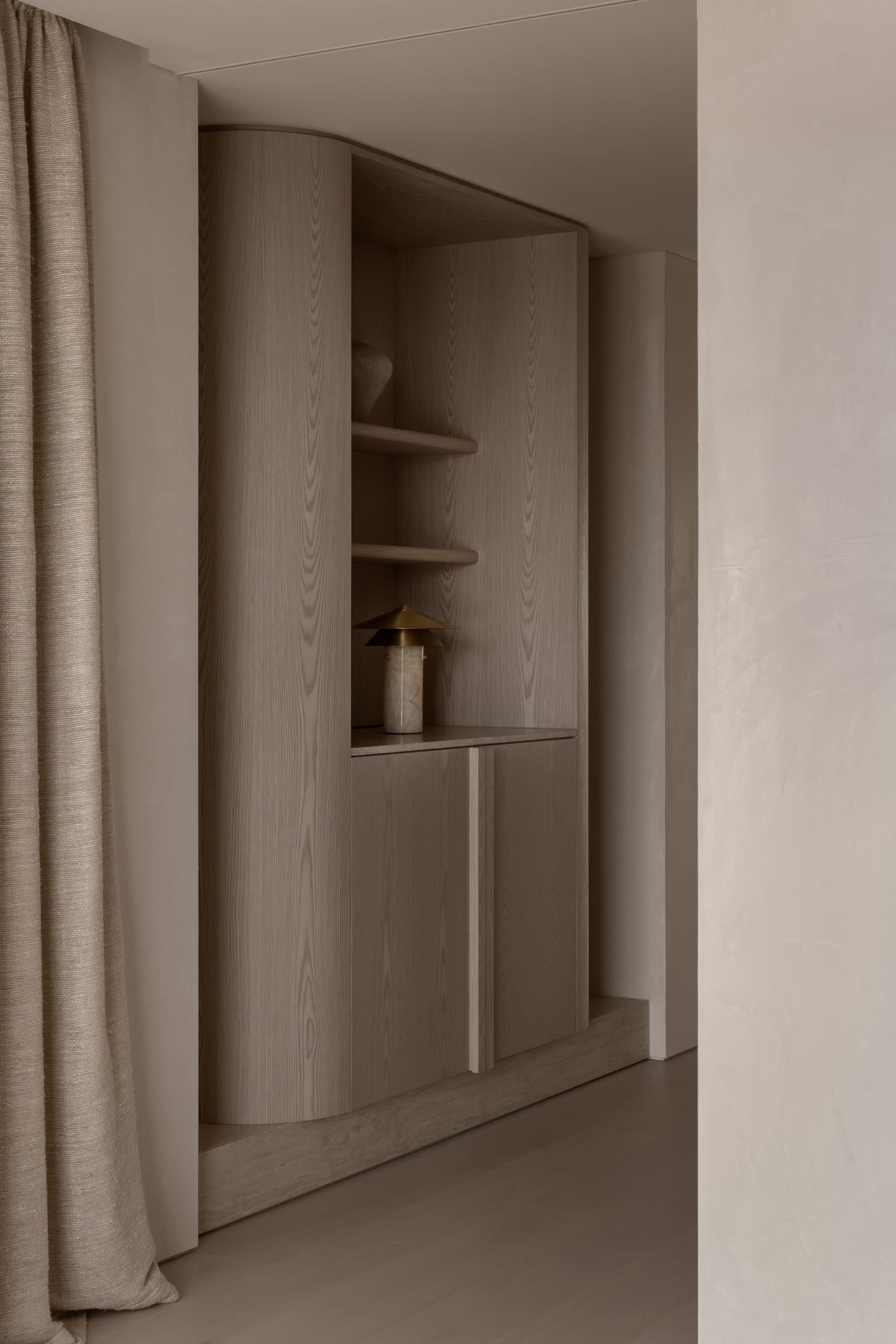 A modern minimalist interior featuring wooden cabinets and shelves.