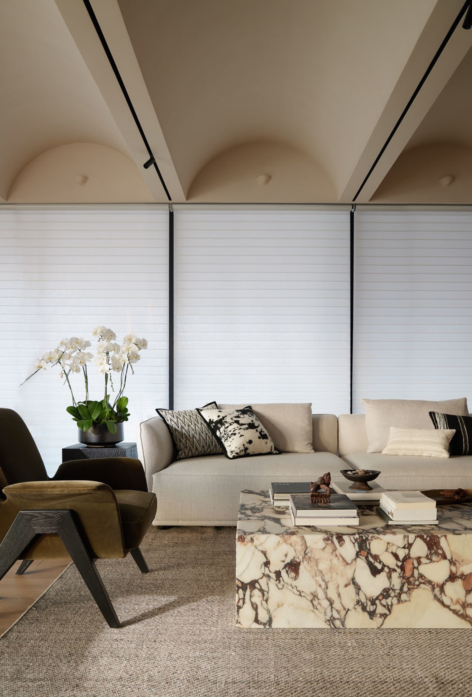 現代客廳內擺放布料與天鵝絨面料沙發，搭配大理石咖啡桌及落地窗