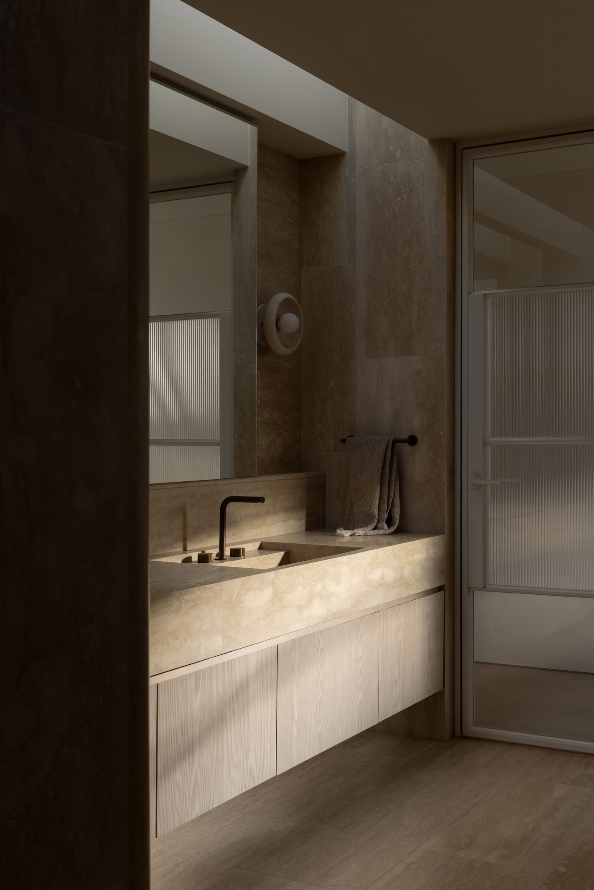 Modern bathroom with marble sink and countertop, featuring a towel rack and a mirror above the sink.