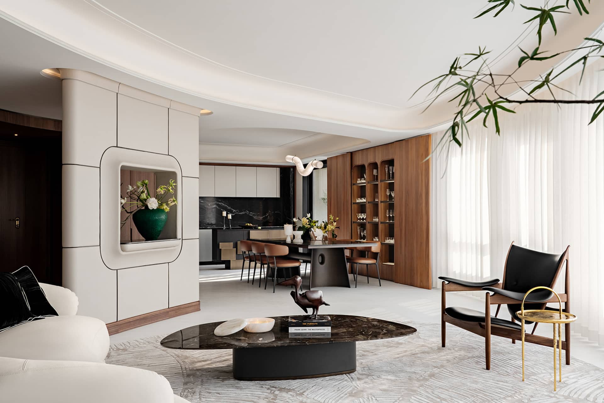 A modern living room with marble coffee table, leather seating, wooden accents, and glass cabinets.