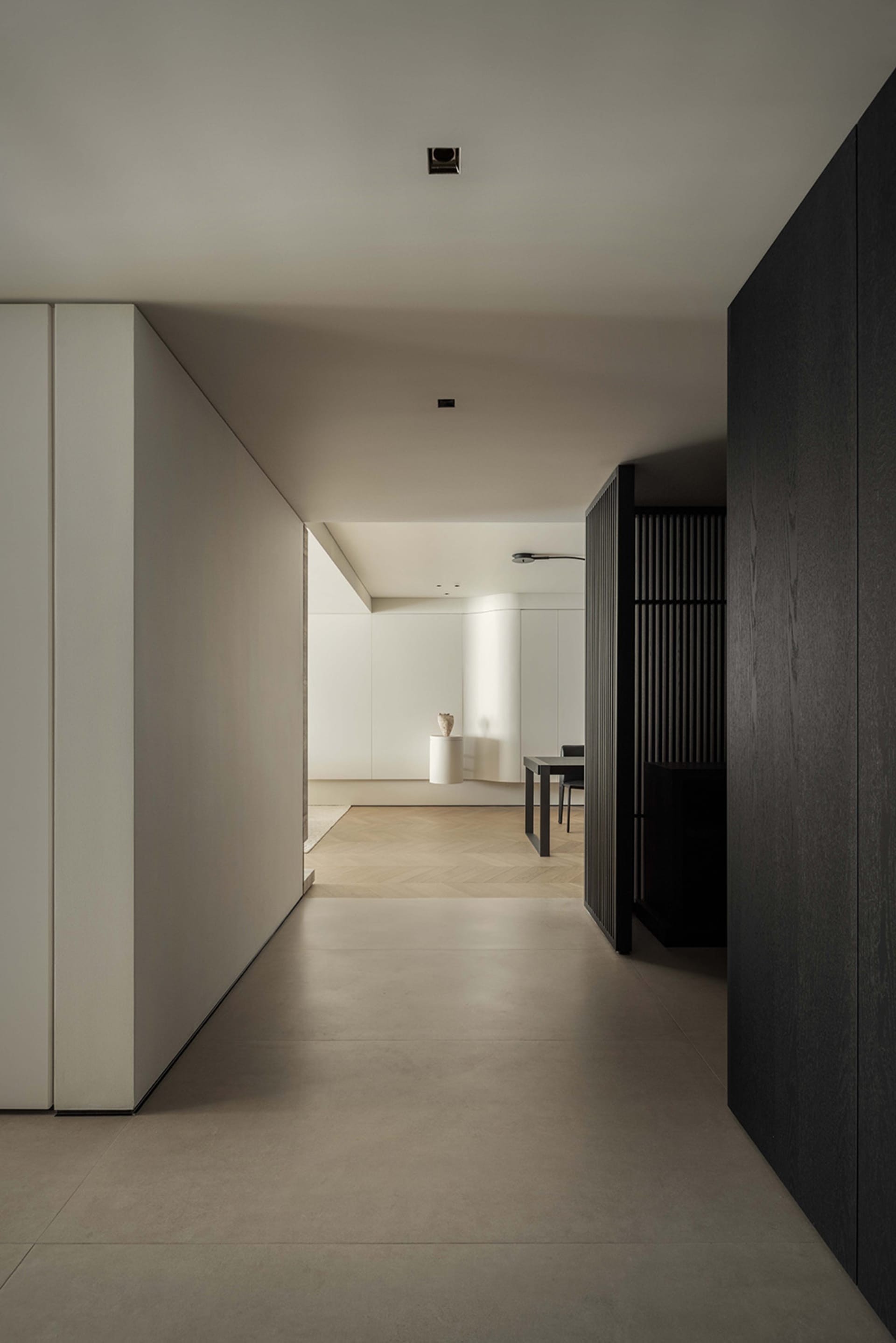 A minimalist modern hallway with concrete floors, wooden walls, and metal railings.