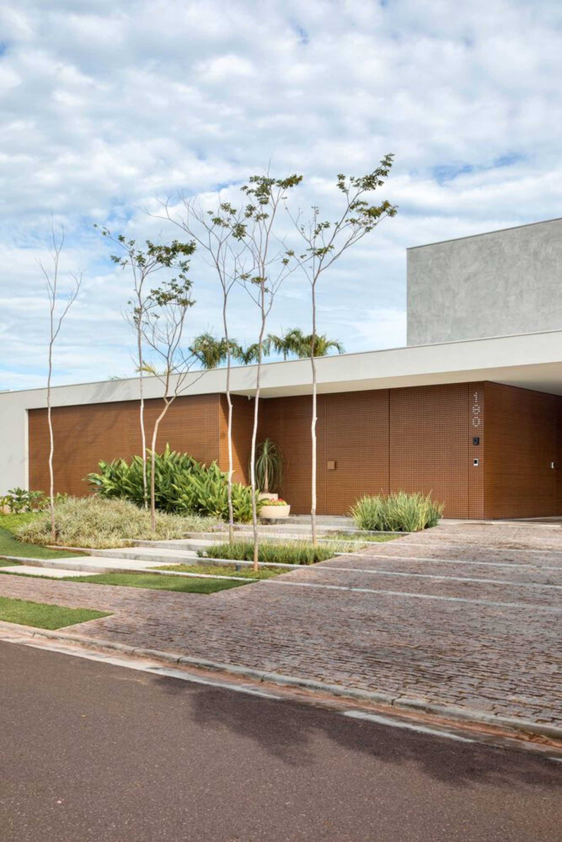 Modern residential exterior featuring sandstone and cement materials.