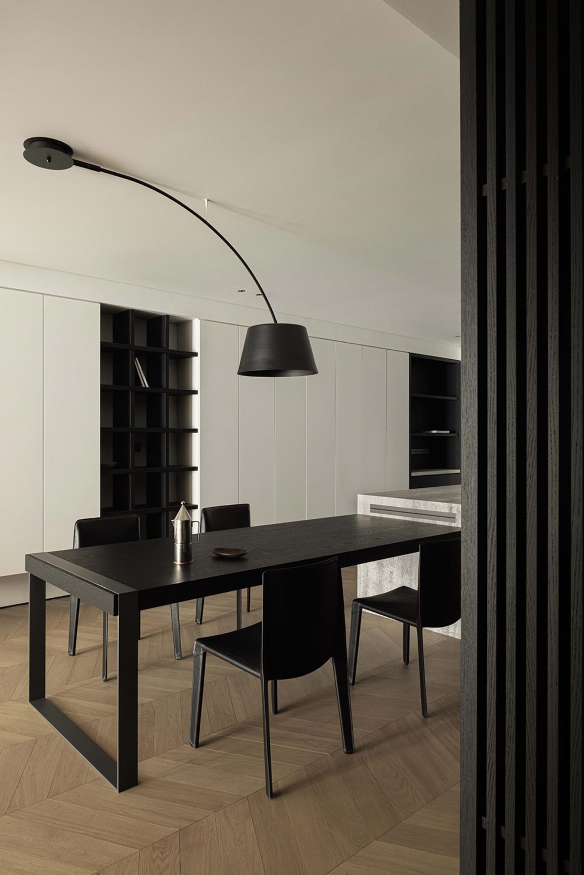 Modern dining room featuring a black dining table and matching chairs, complemented by a black floor lamp.