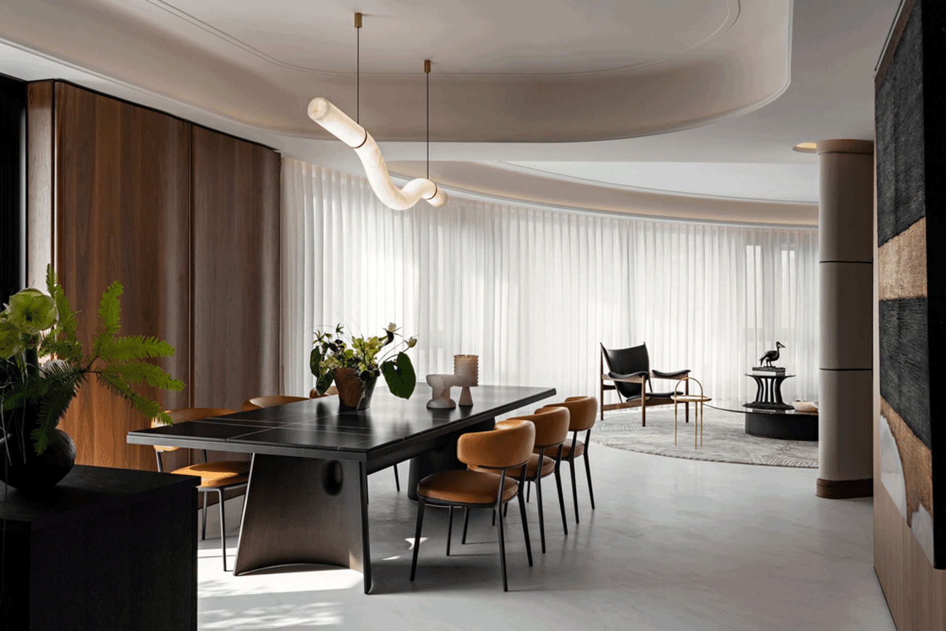 A modern dining room featuring dark marble tables and chairs, wood accents, and white curtains.