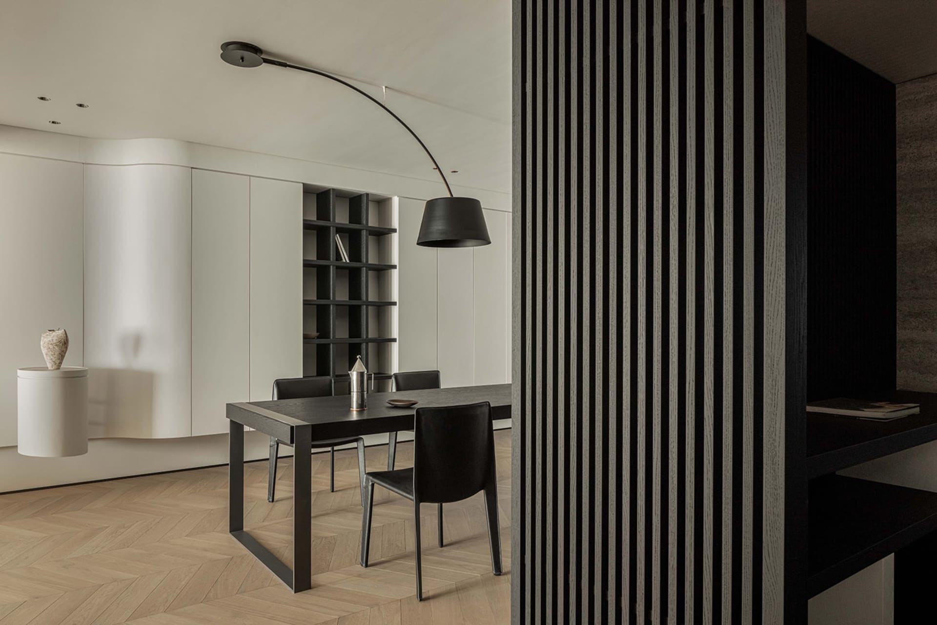A modern living space featuring black tables and chairs with black stripes on a wooden floor.