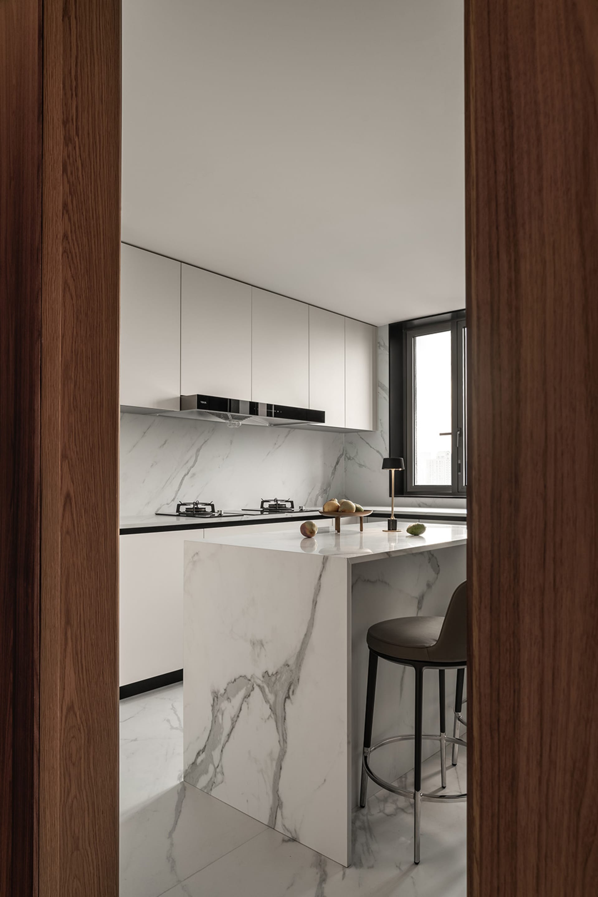 Modern minimalist kitchen with marble countertops and minimalist design features.