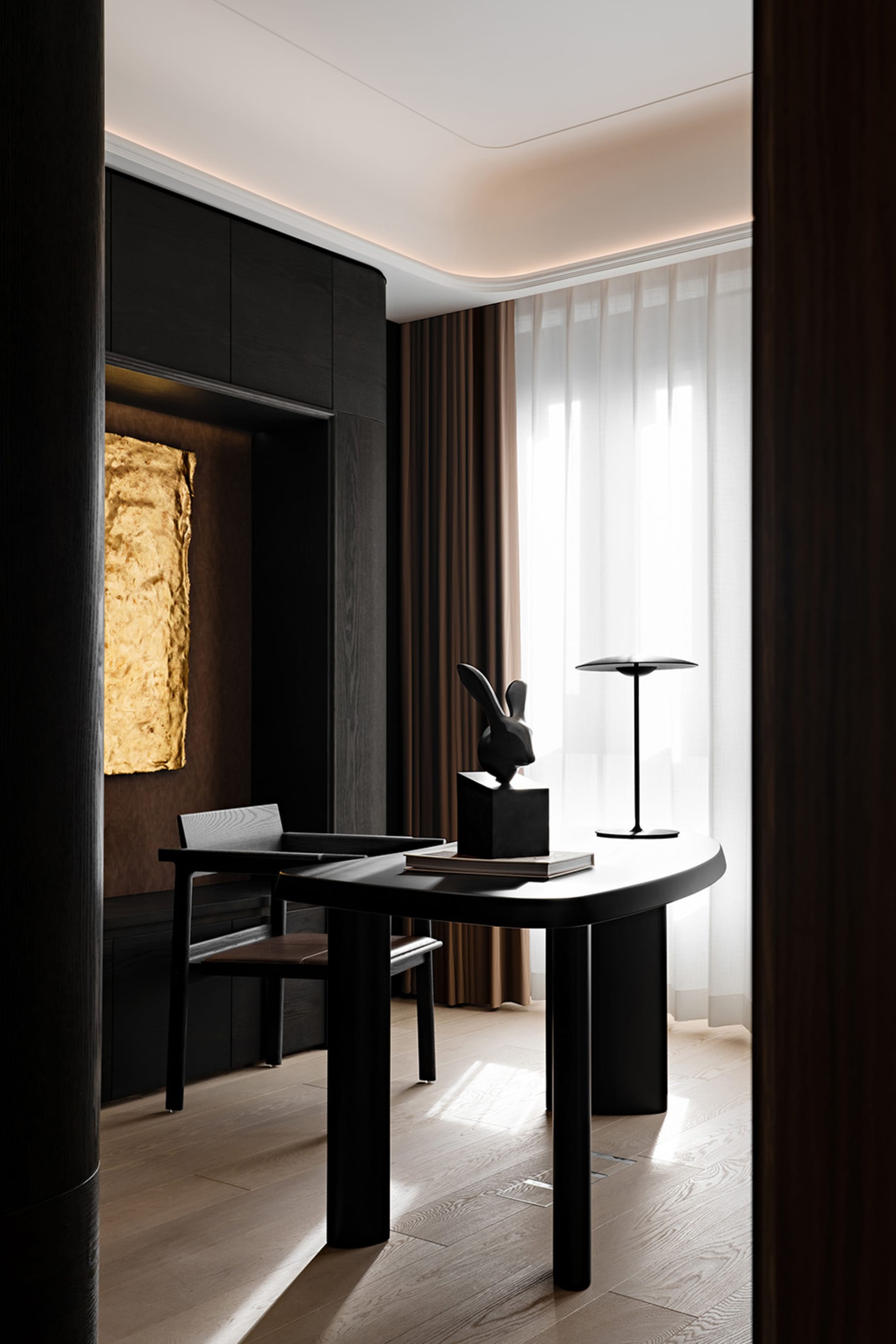 A modern home office featuring a black wooden desk with a rabbit sculpture and a lamp.