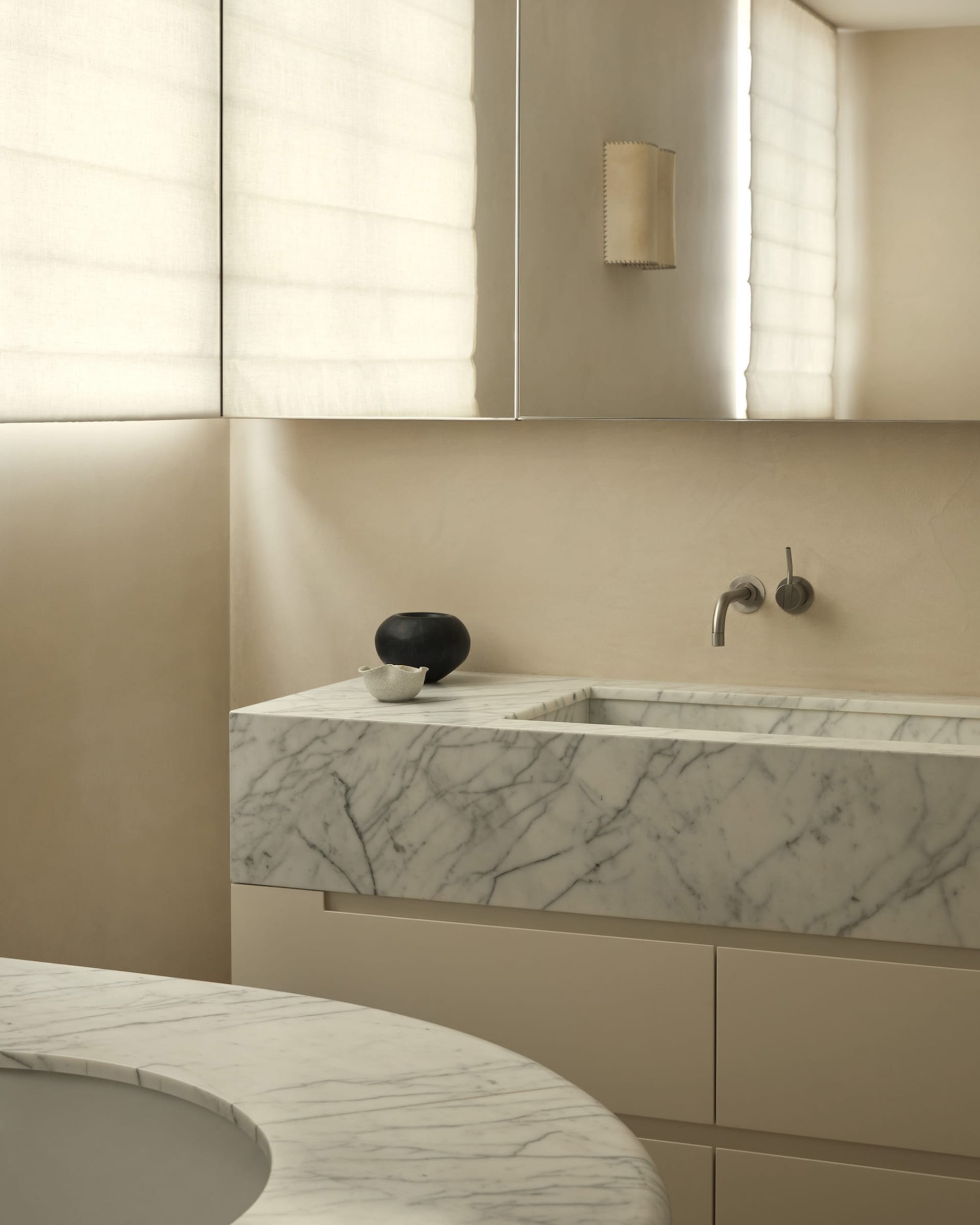 Modern minimalist bathroom featuring a white marble countertop with integrated sink and a neutral color palette.