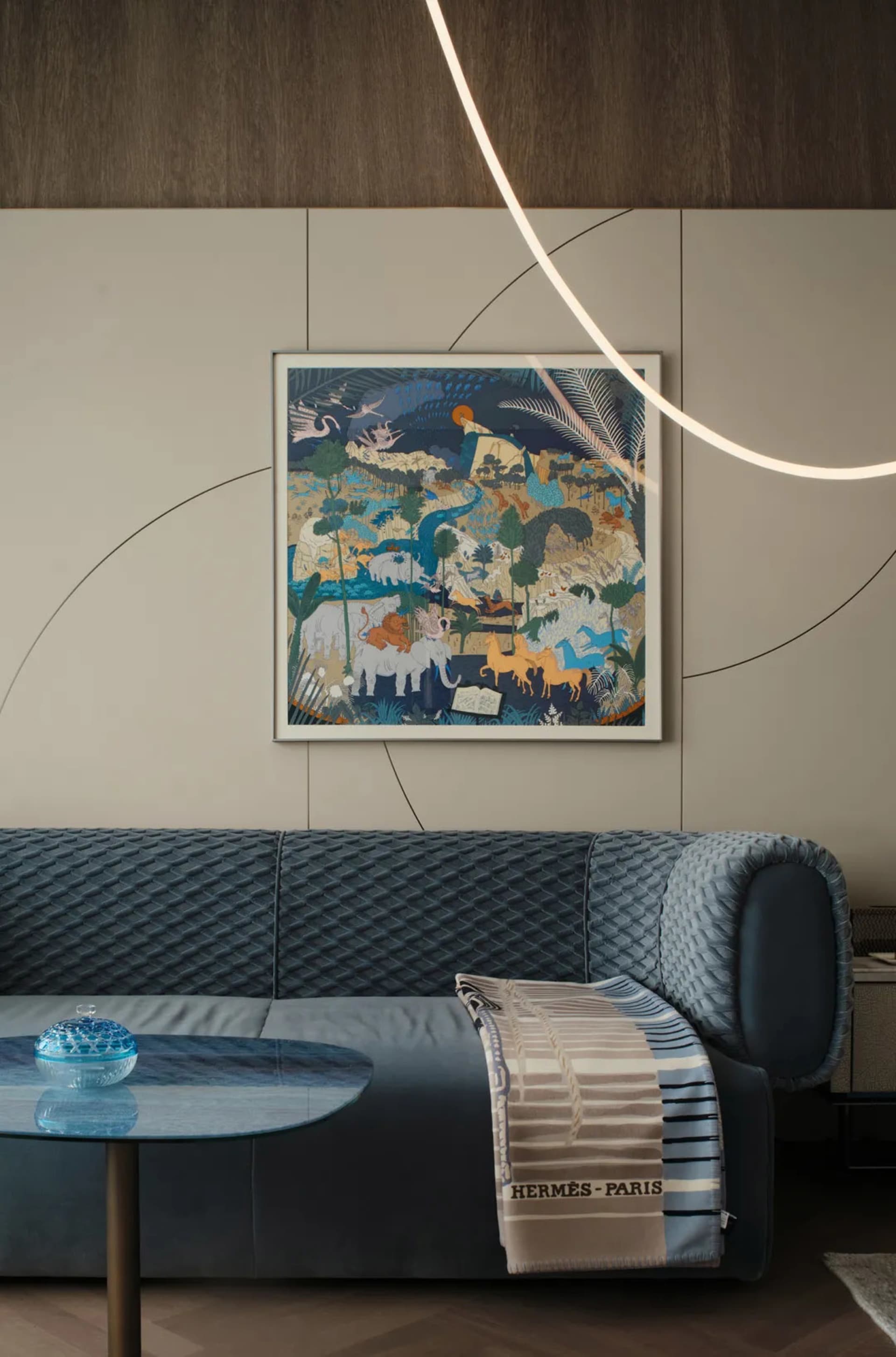 A modern living room featuring a blue sofa, vinyl rug, and abstract painting.