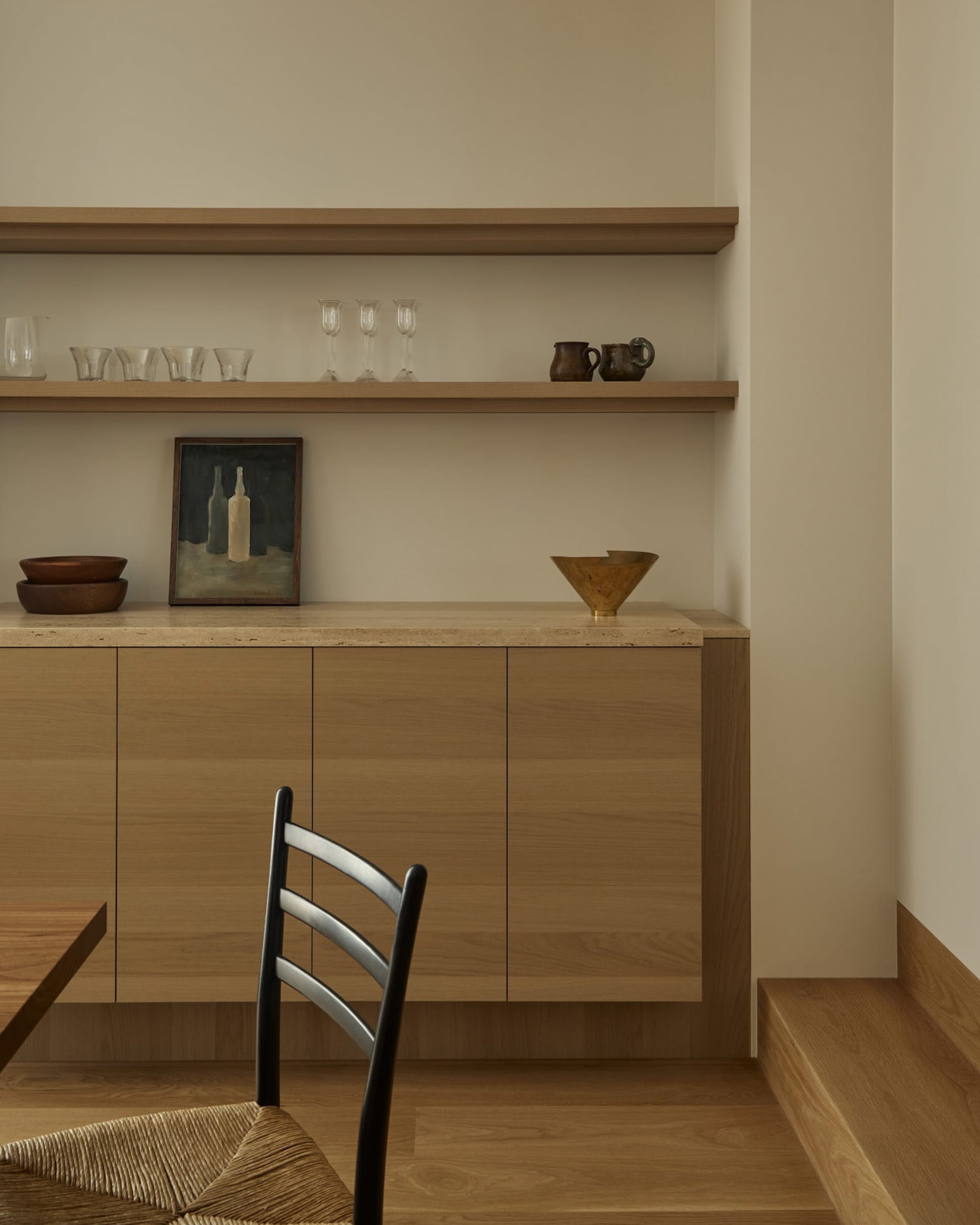 A modern Scandinavian kitchen featuring sleek wooden storage units adorned with minimalist decorative items.