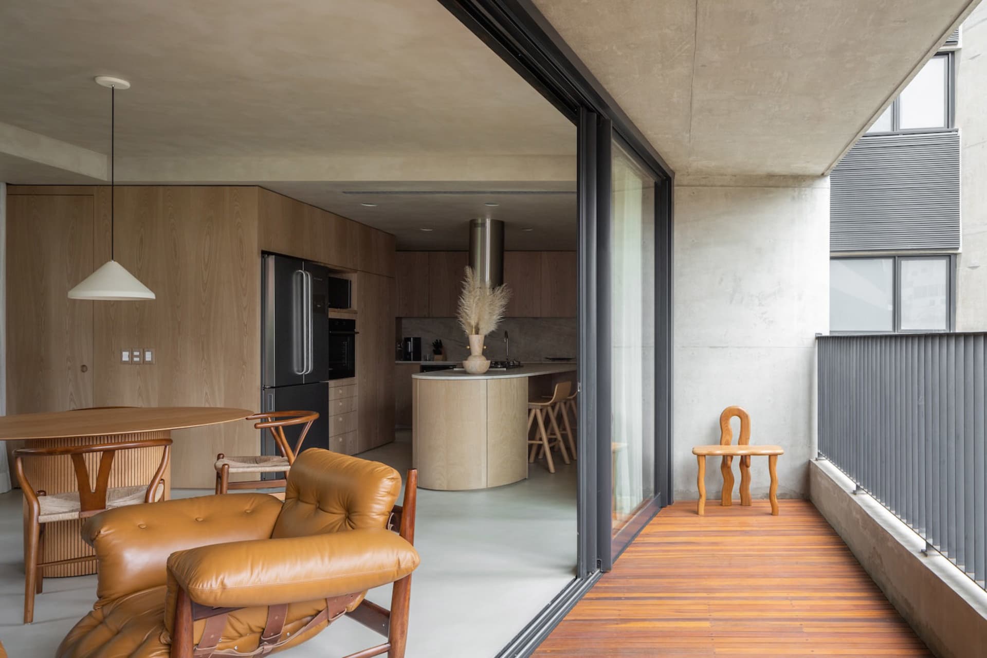 A modern residential kitchen featuring wood and concrete materials.