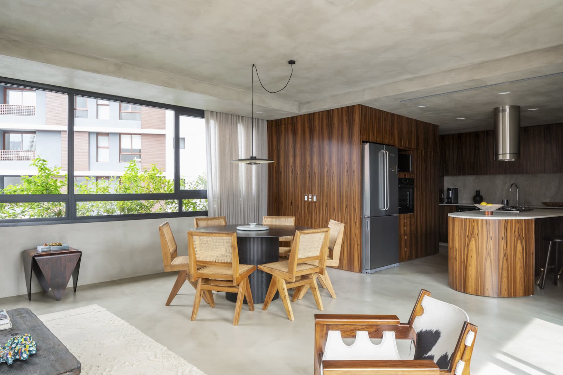 Modern apartment interior with open-plan living, dining, and kitchen areas in a minimalist design approach.