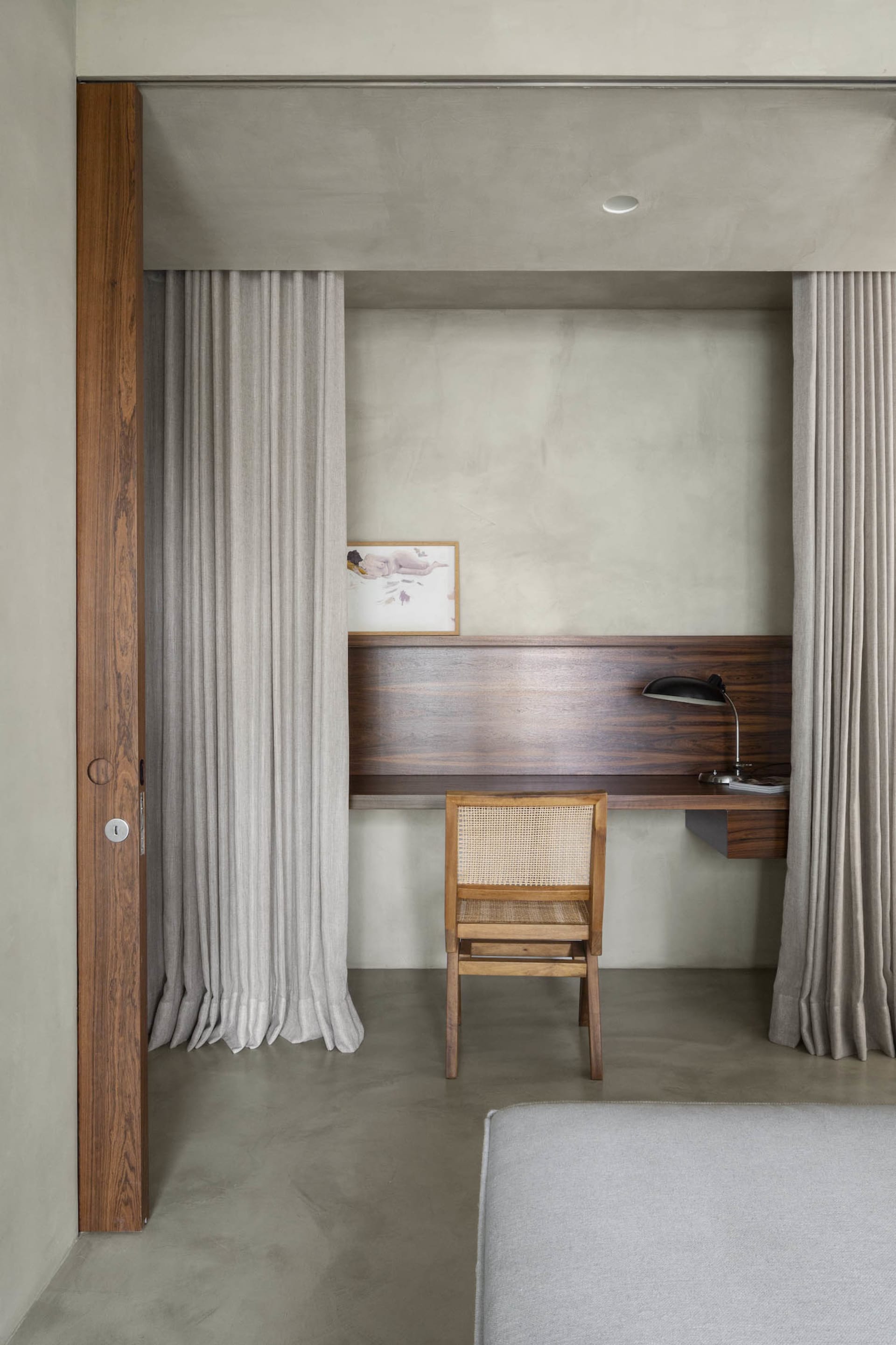 A modern minimalist workspace featuring a wooden desk and wooden chair.