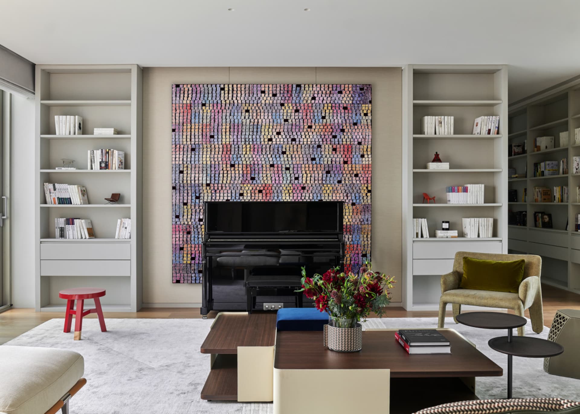 Modern minimalist living room with a wooden coffee table, fabric armchair, and abstract wall mural.