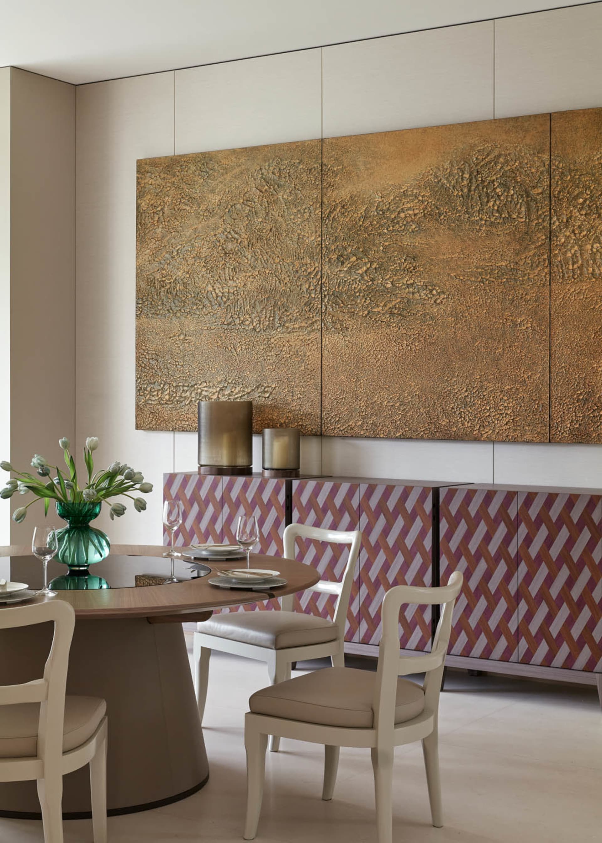 A modern dining room with a round wooden table, white chairs, and ceramic tiles on the floor.