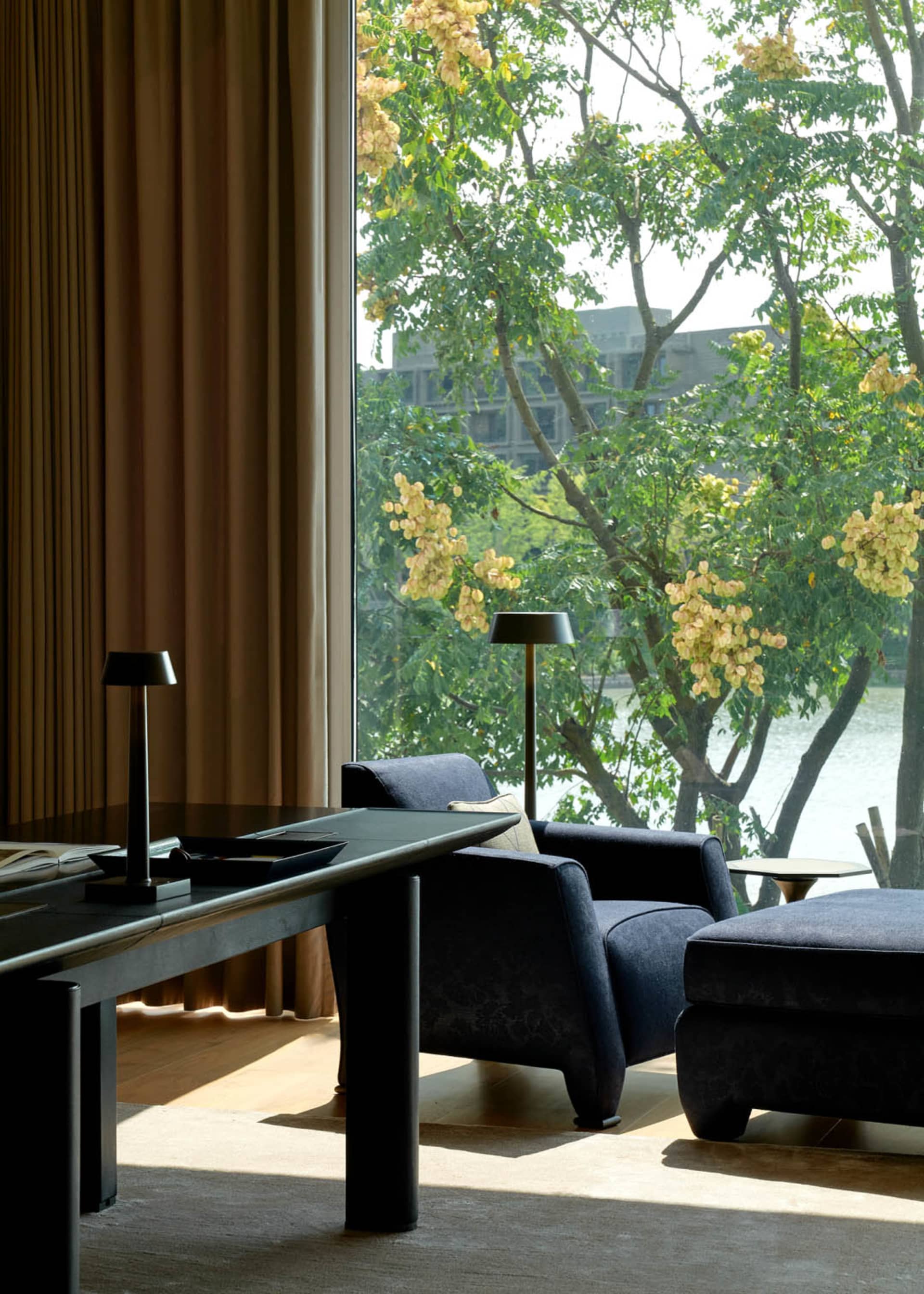 A well-designed modern fashion interior featuring a textured cloth fabric living room with a view of greenery outside.