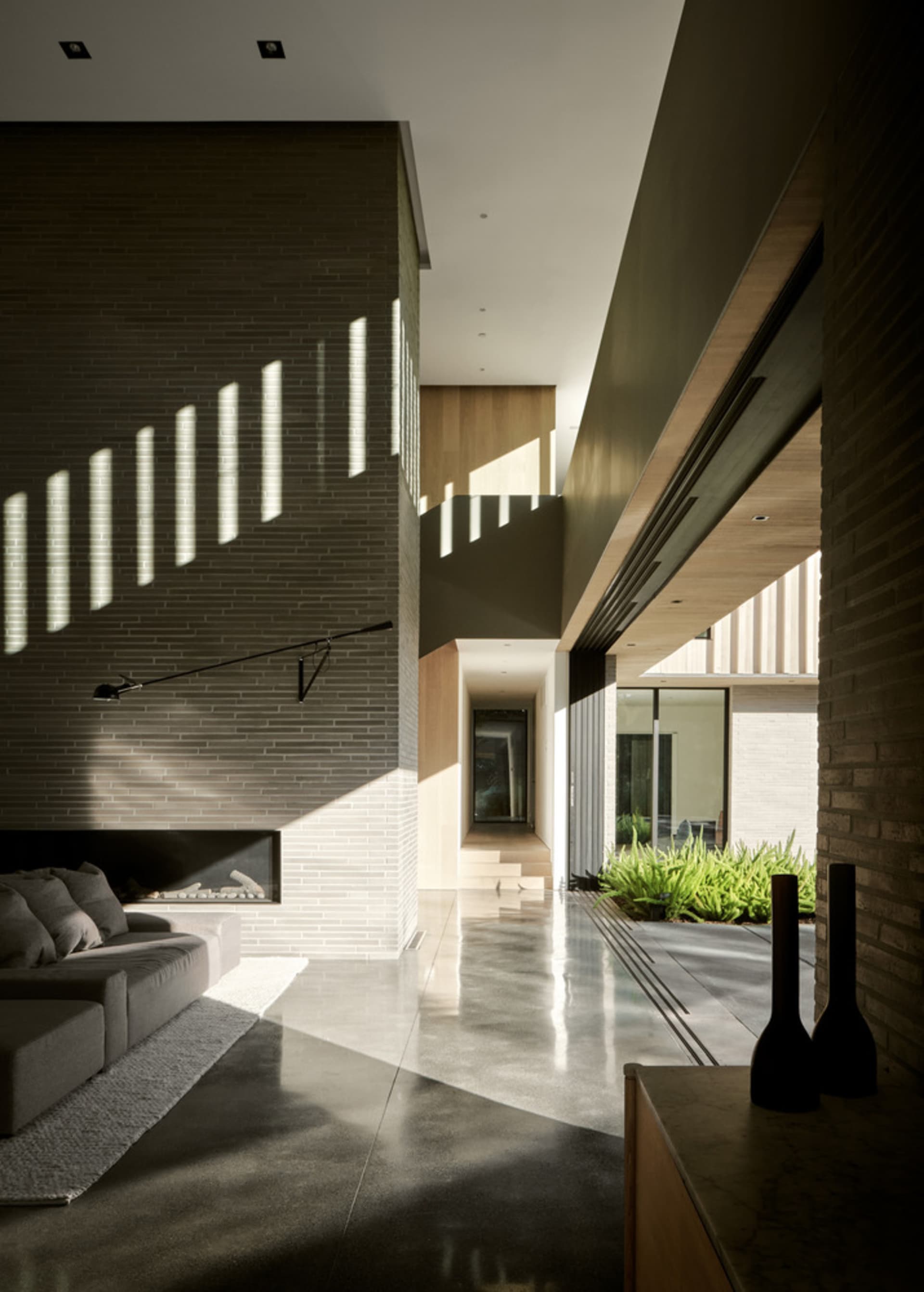 Contemporary living room featuring concrete walls, minimalist furniture, and natural light.