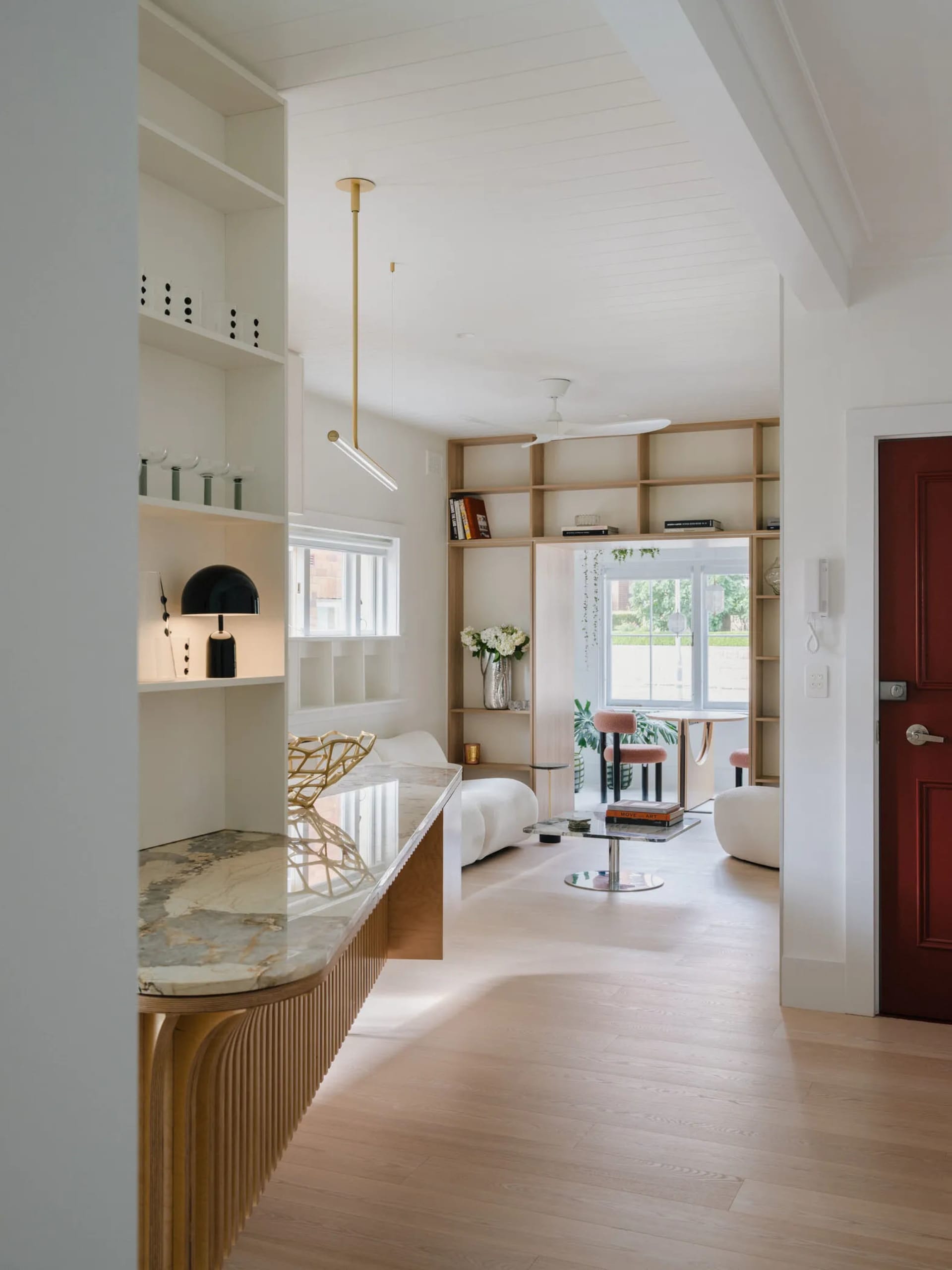 A modern residential interior with a neutral color palette featuring light wood floors, white walls, and a combination of met