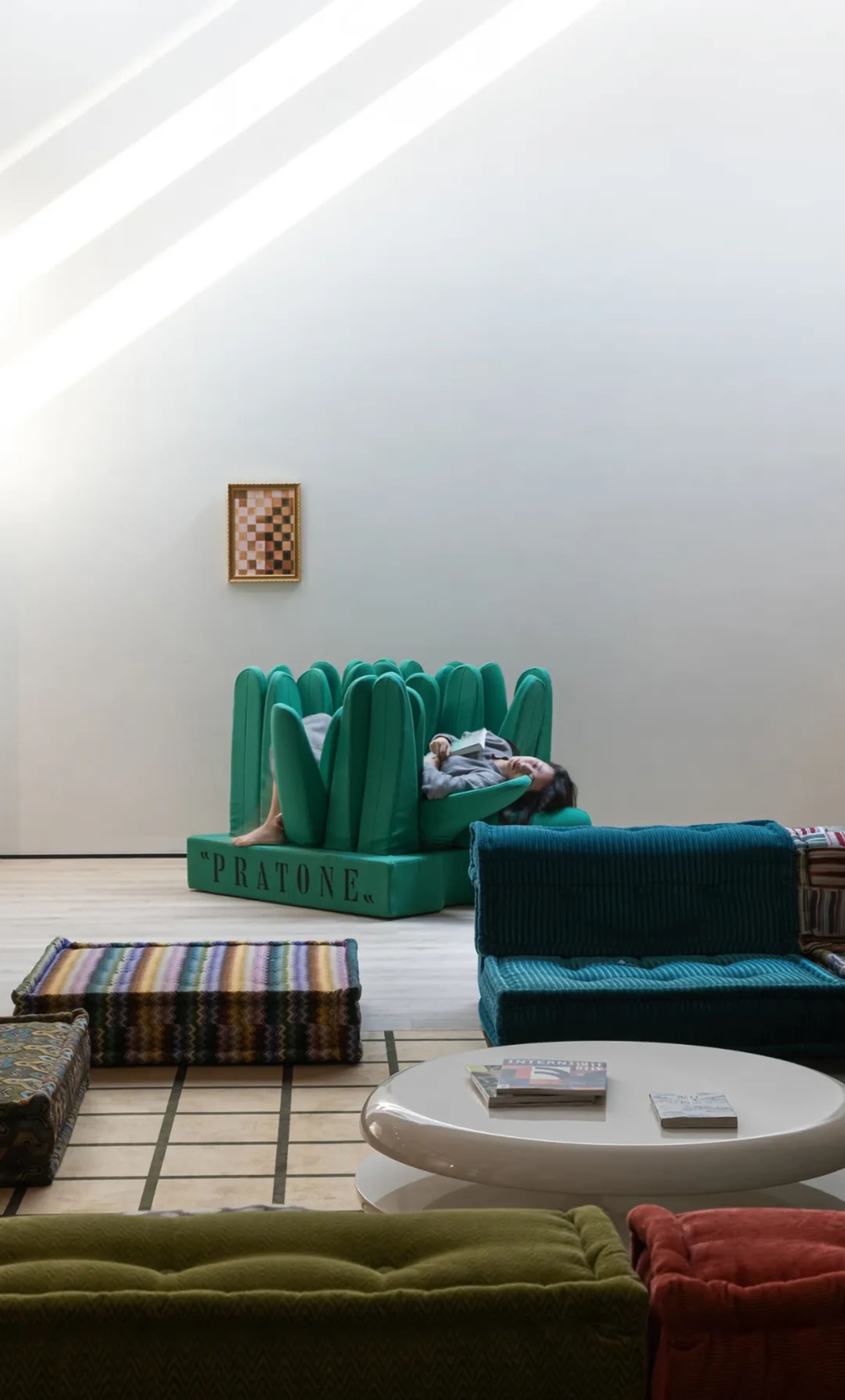 A modern interior design featuring a teal sofa with a concrete floor and high ceiling.