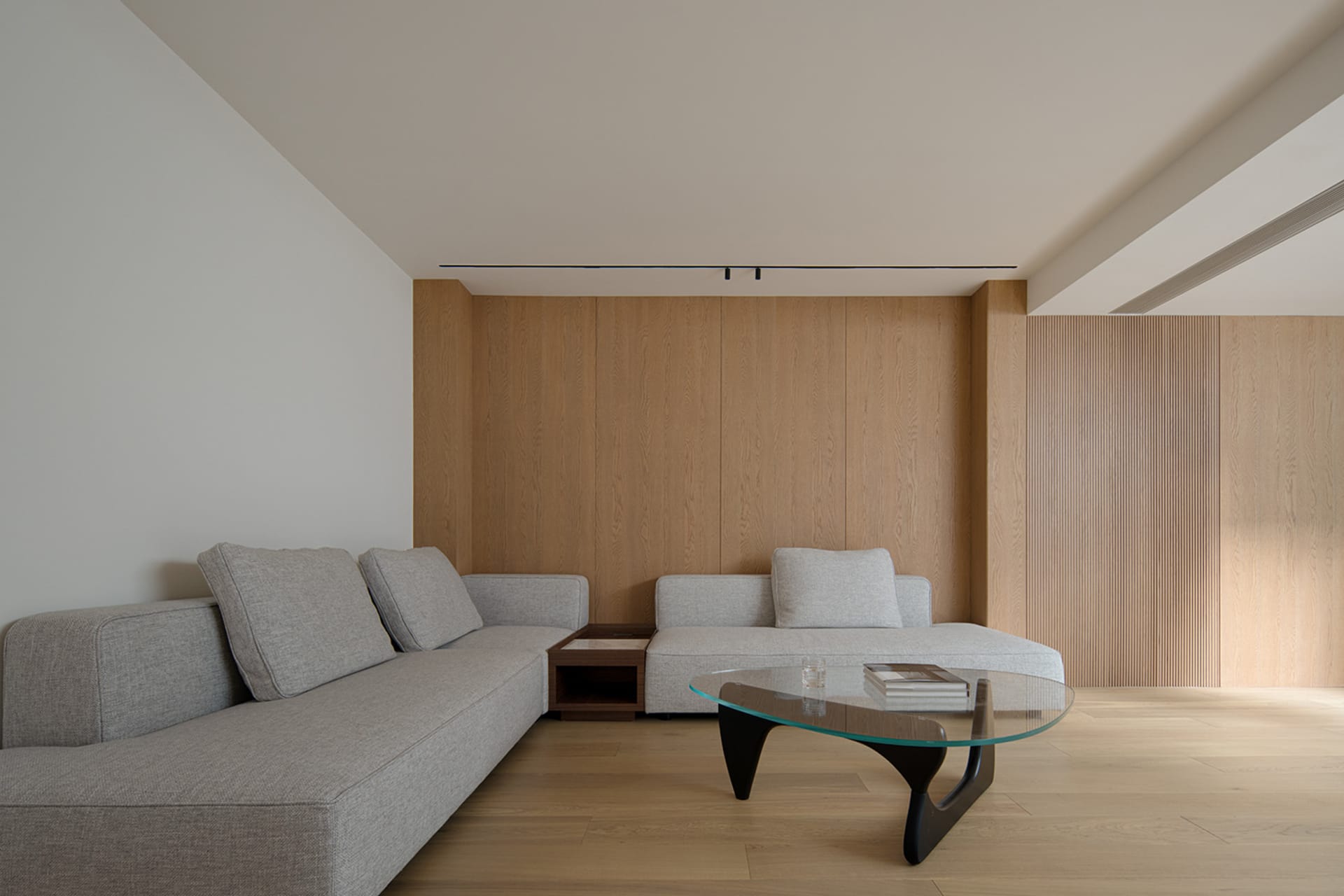 Modern living room with grey fabric sofas and wooden walls