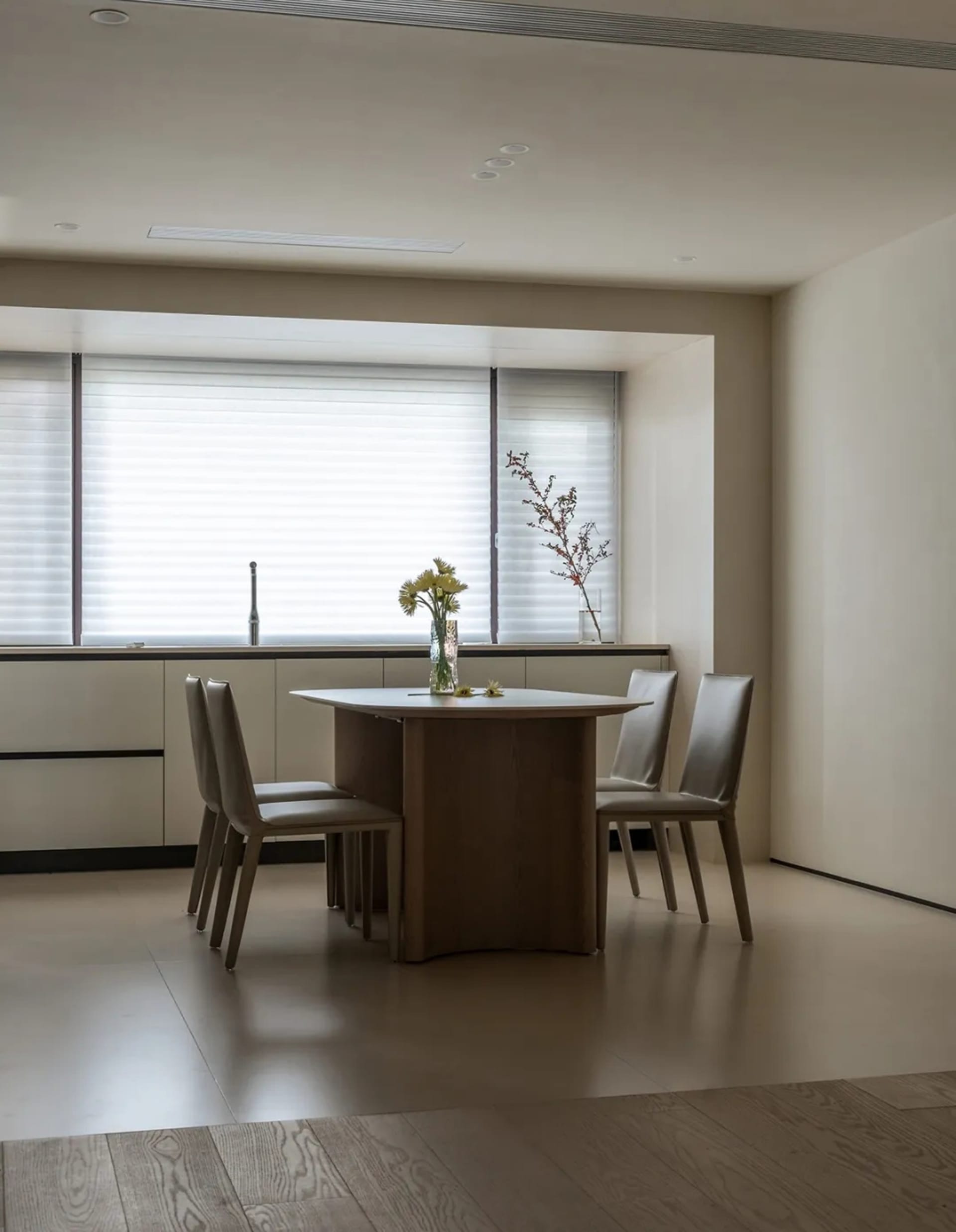 A modern kitchen featuring wooden cabinetry and a dining table with chairs.
