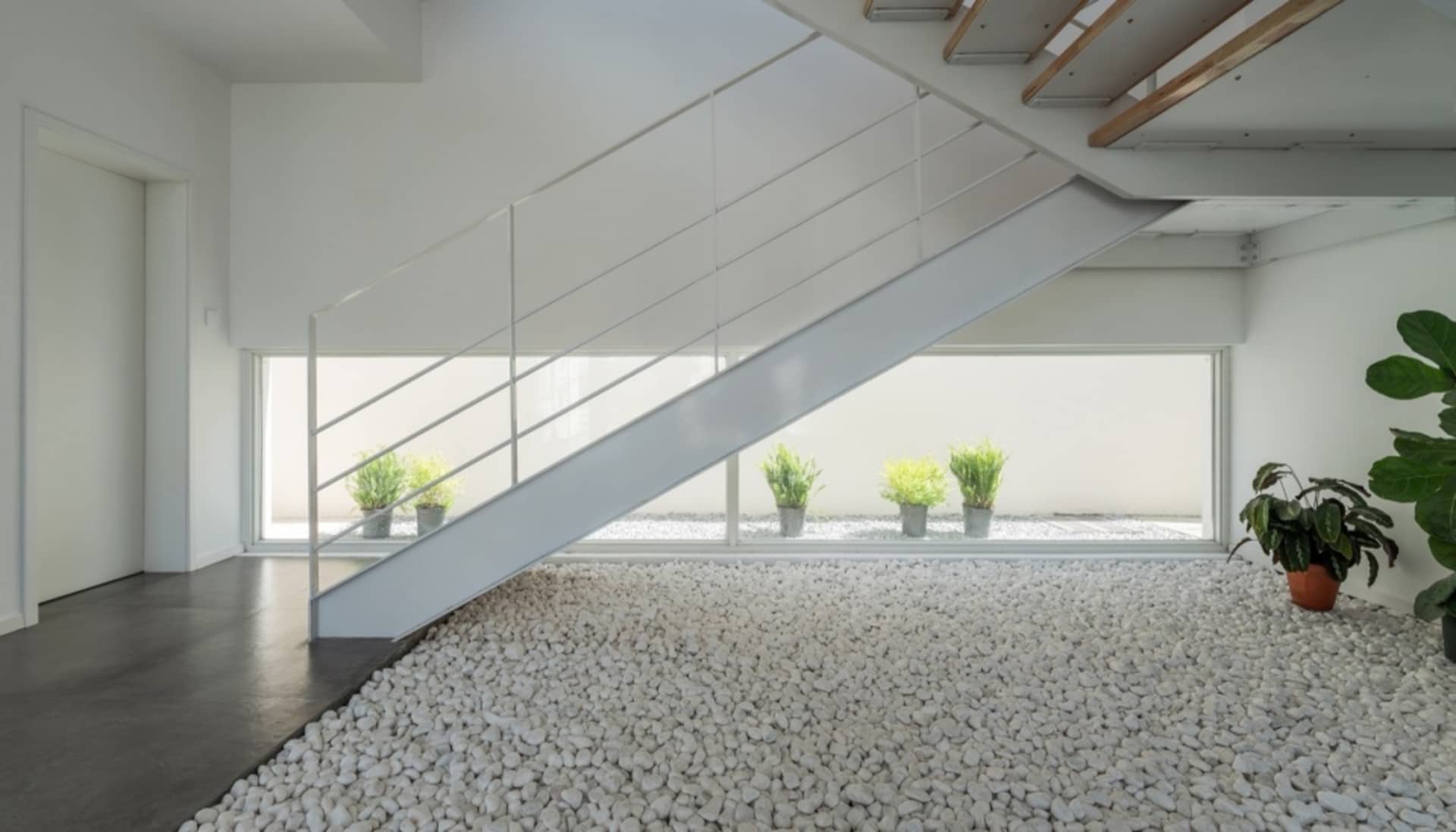 A minimalist, modern interior featuring a concrete floor and white walls.