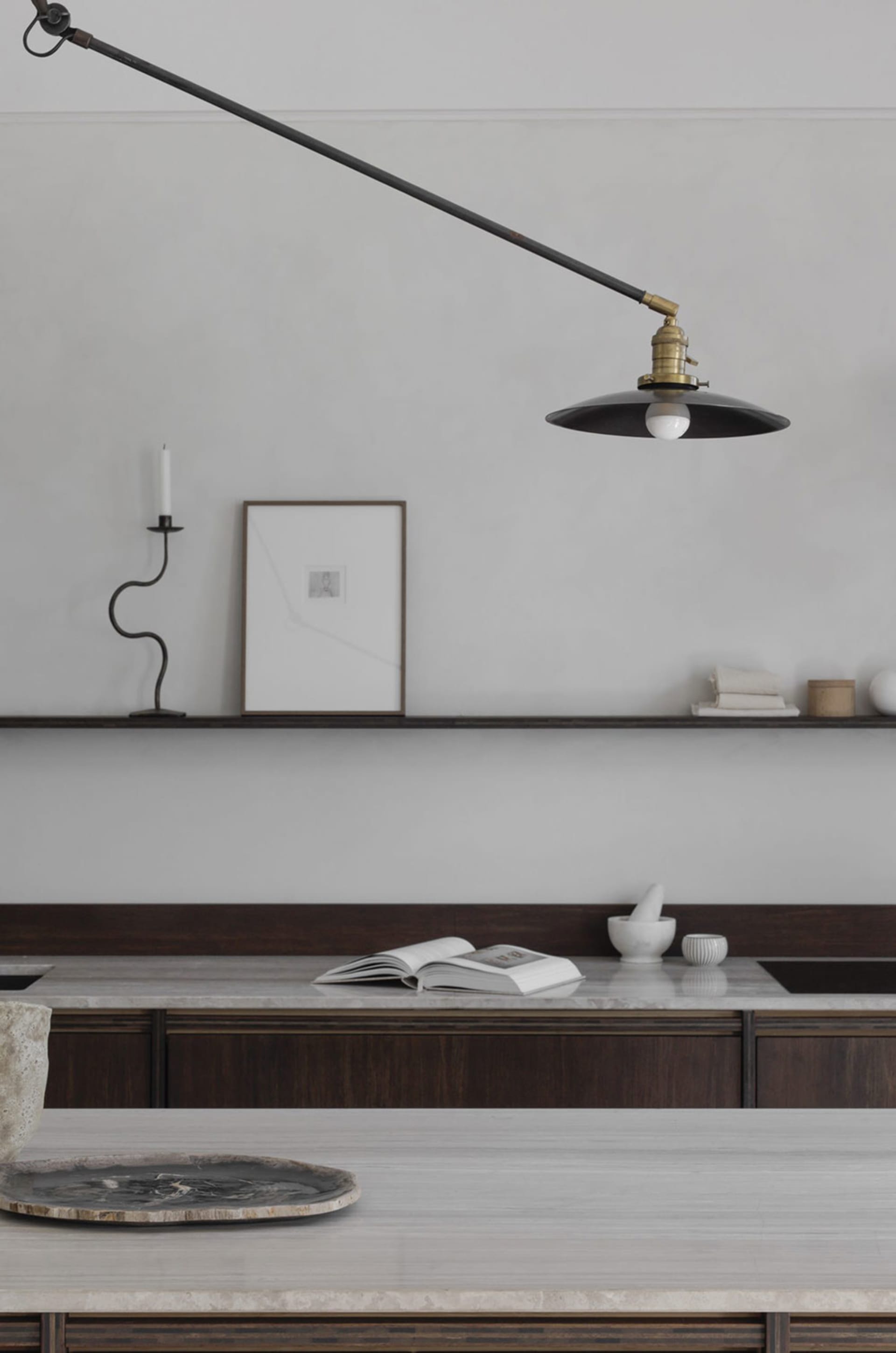 A minimalist kitchen featuring marble countertops and wooden cabinets.