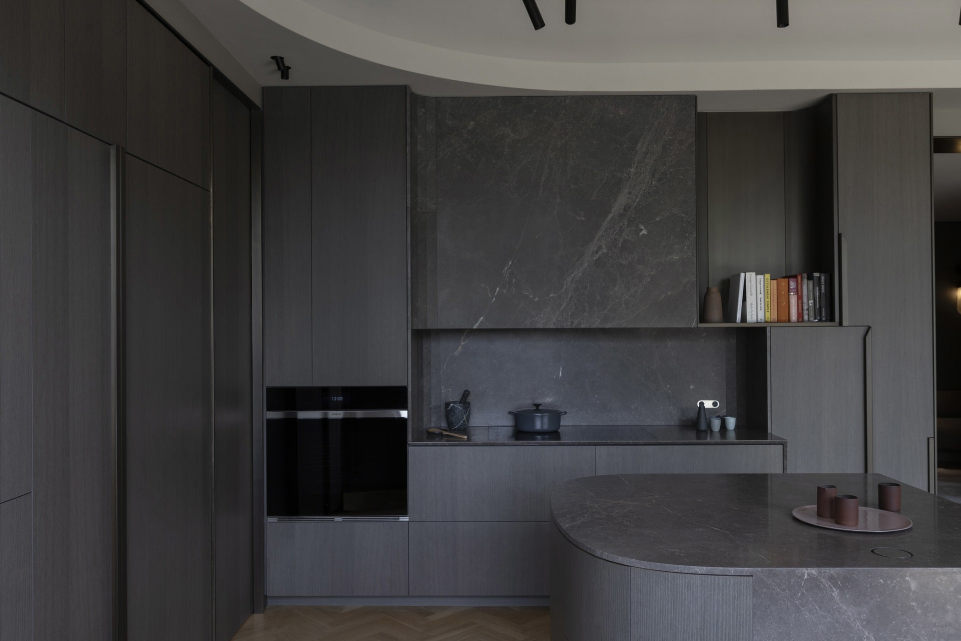 A modern kitchen featuring dark marble countertops and cabinets.