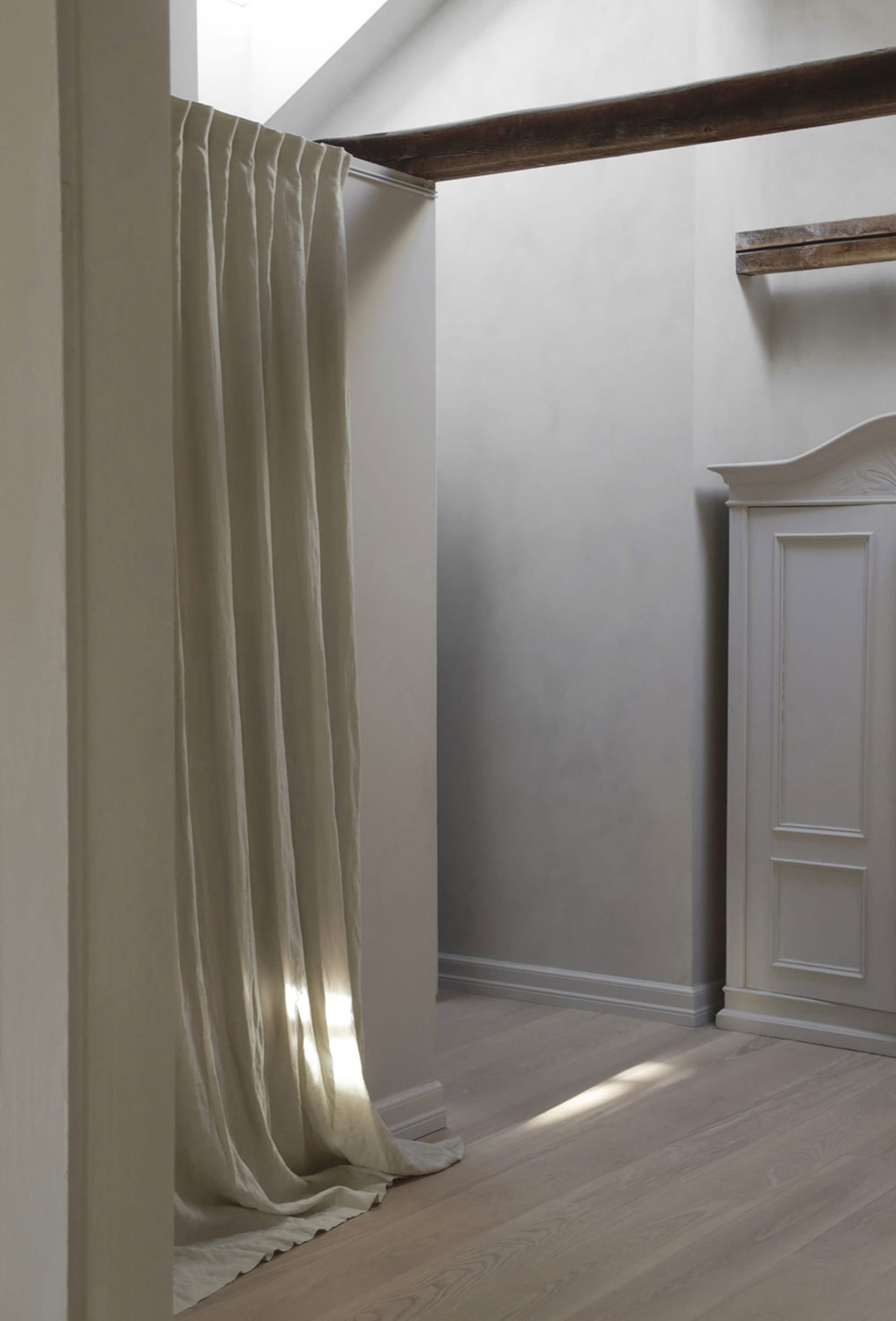 A minimalist interior space with light-colored fabric and wooden elements