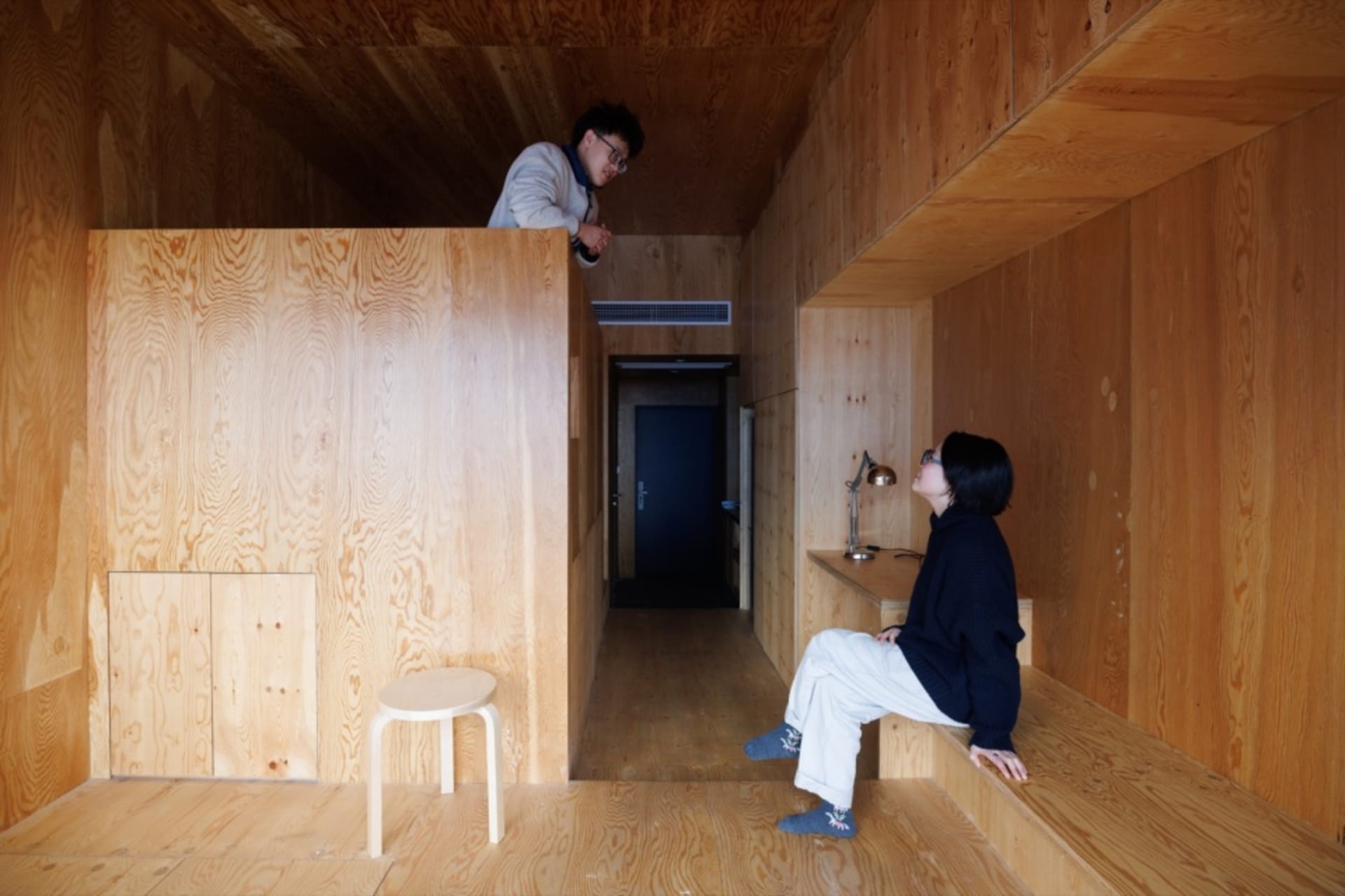 A minimalist living space with wood-paneled walls and floors.