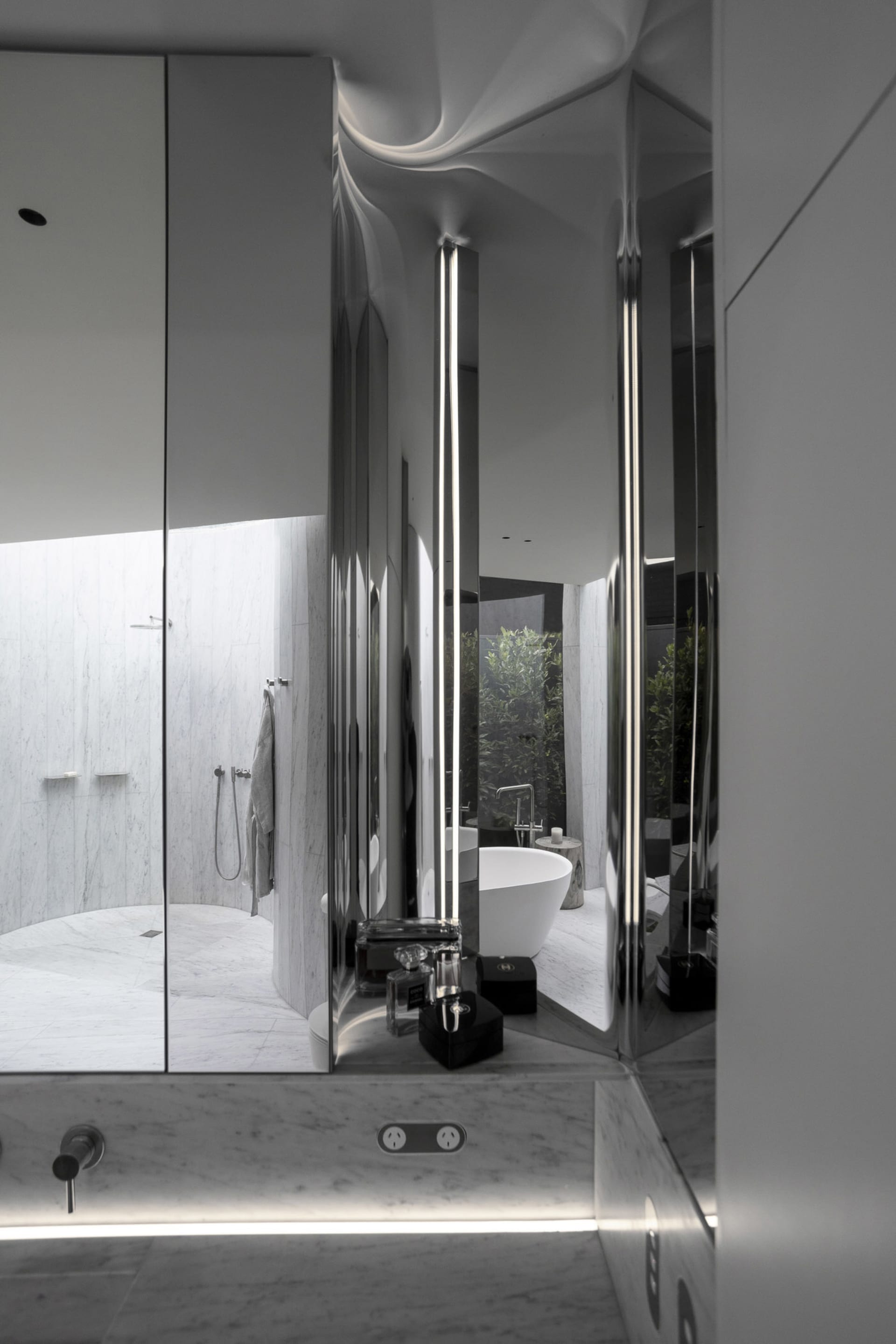 A modern minimalist bathroom with marble tiles and fixtures.