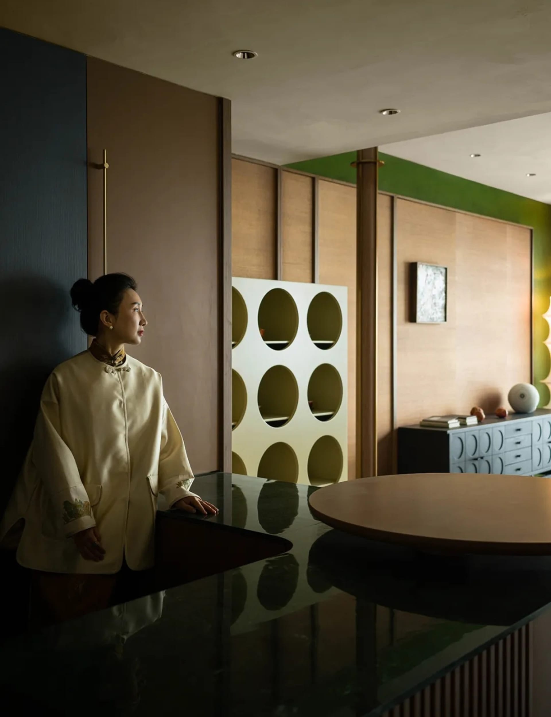 A modern living room with a wooden floor, glass wall, and contemporary design features.