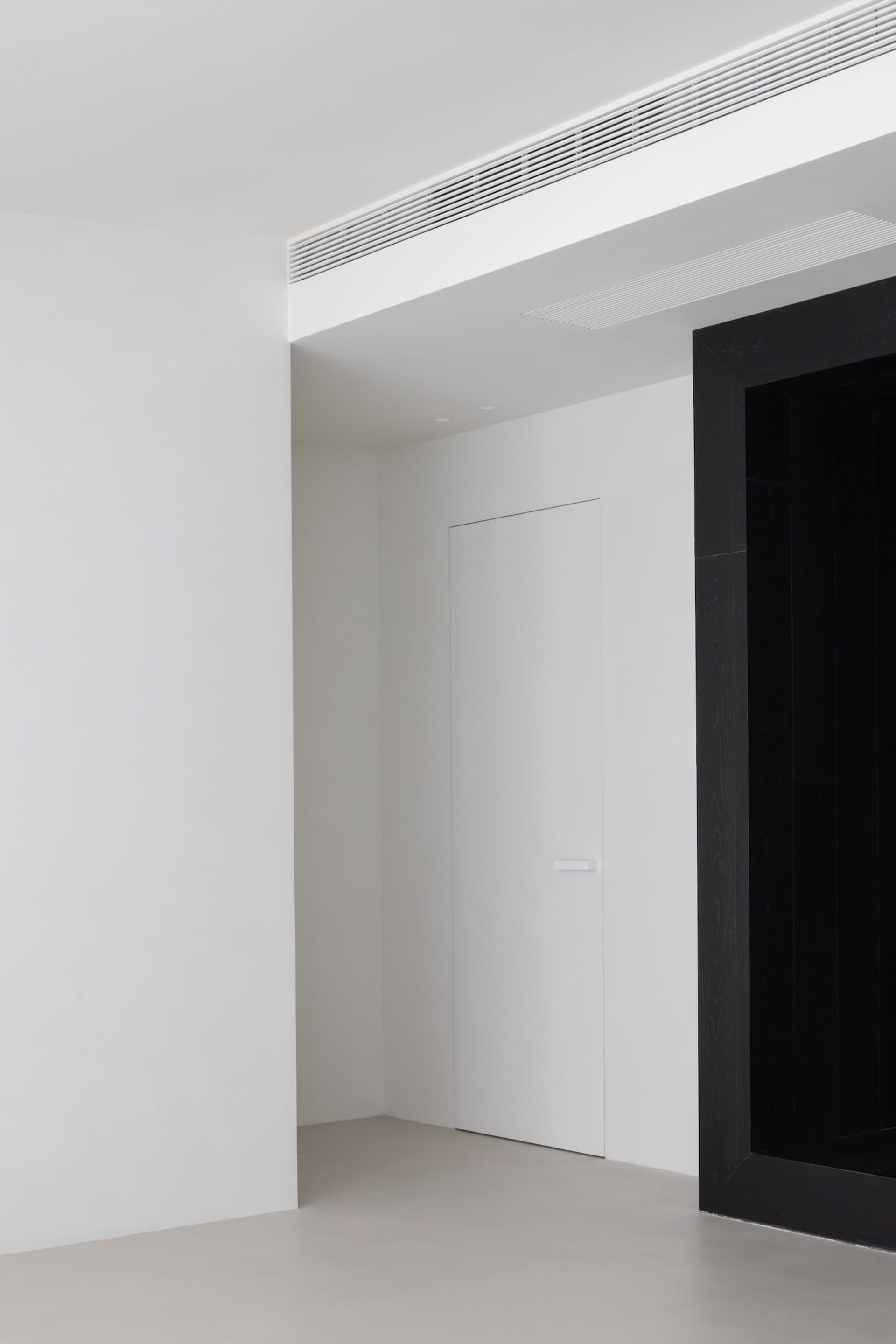 A minimalist interior with white walls and a concrete floor.