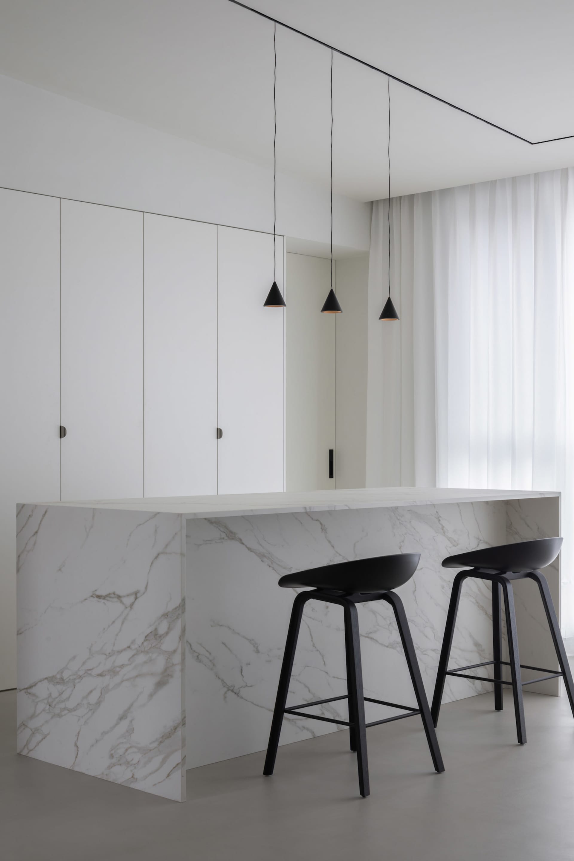 A modern kitchen with marble countertops and minimalist design.