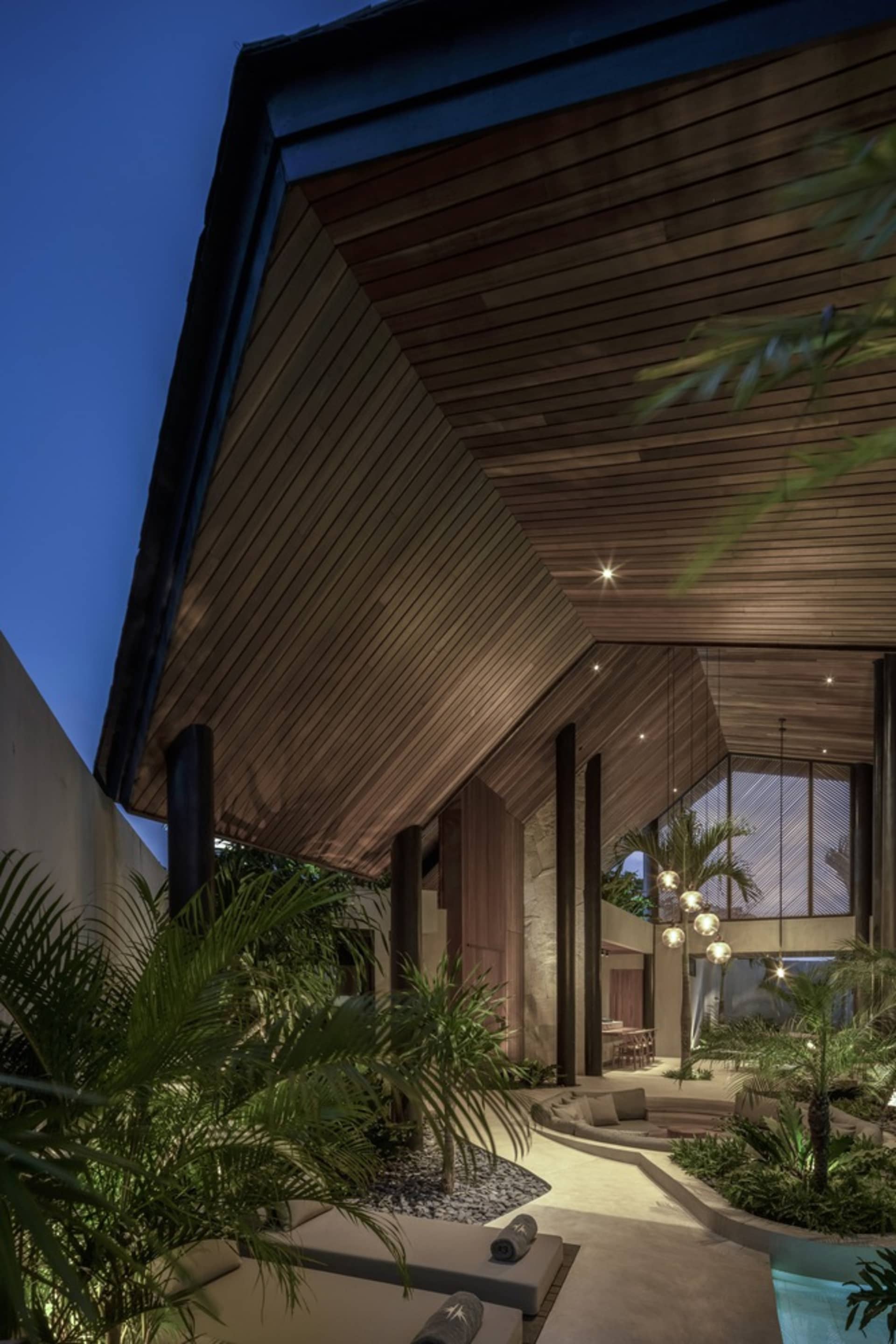A modern residential architecture with a concrete patio and palm trees