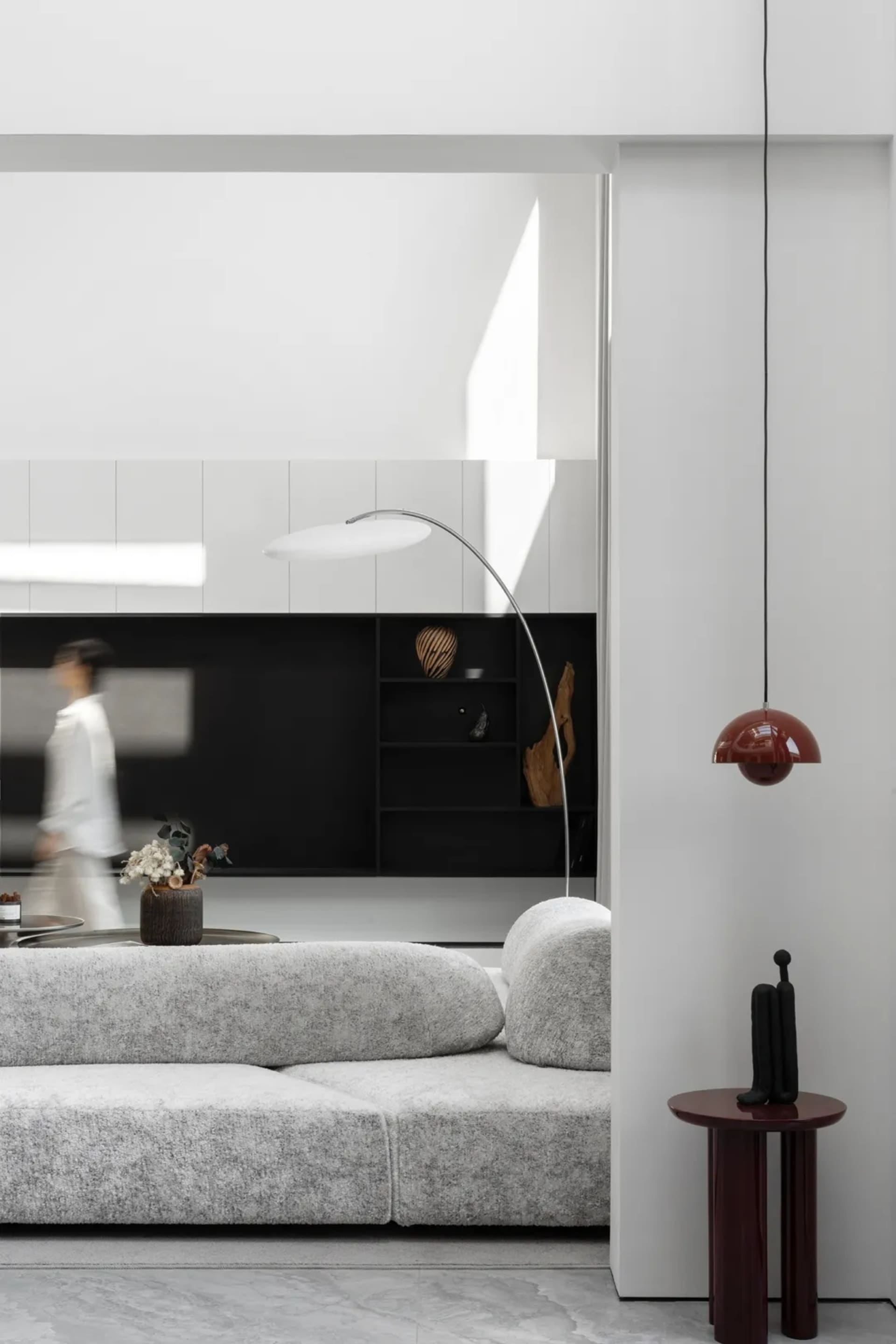 A modern white living room with a textured sofa, minimalist decor, and sleek furniture.