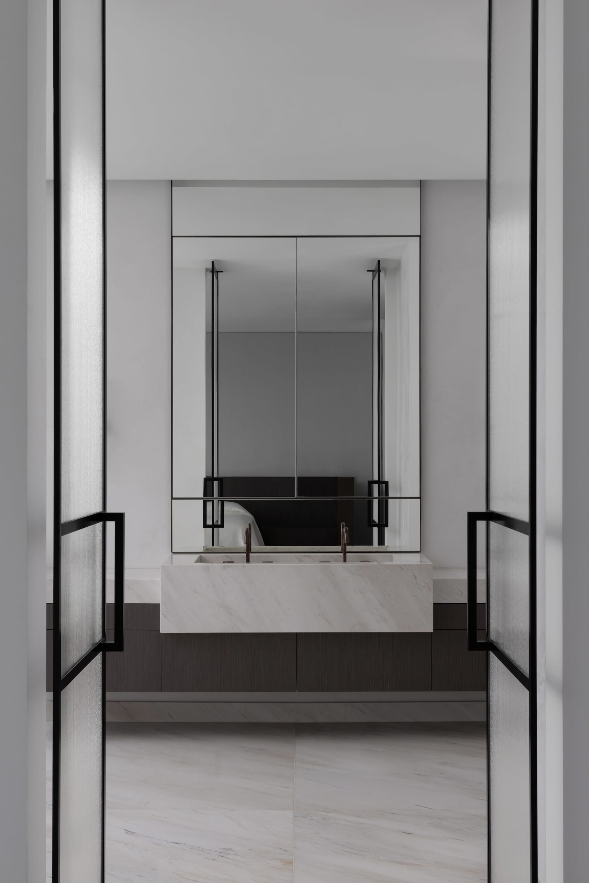 Modern minimalist bathroom featuring a marble sink and large mirror.