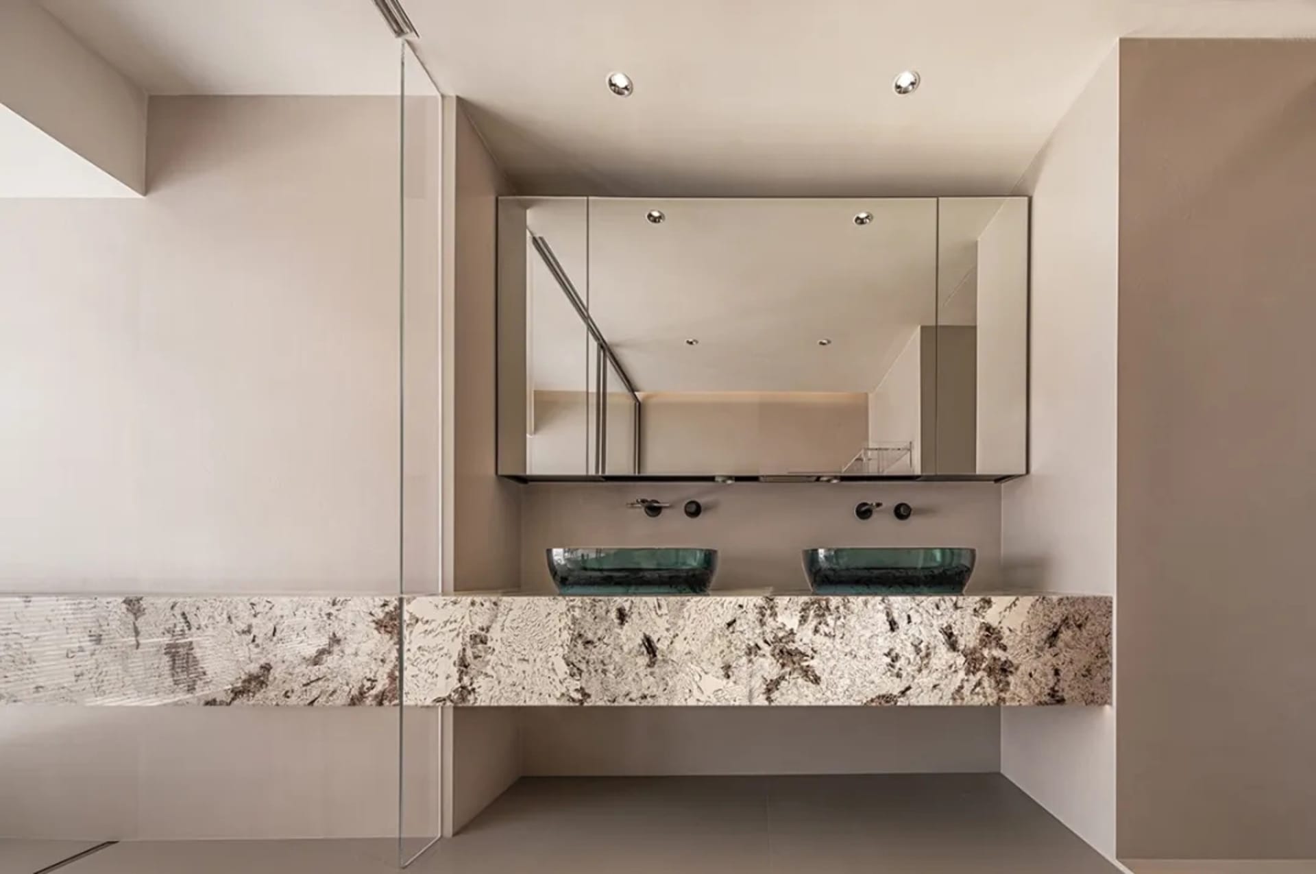 Modern bathroom with glass countertops and white walls.