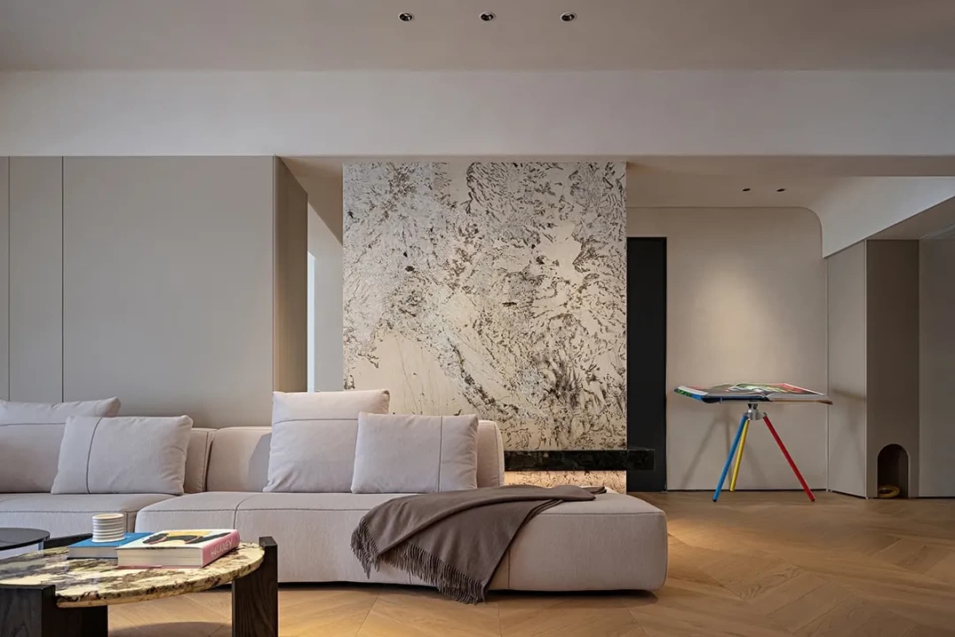 A modern minimalist living room featuring marble and wooden elements.