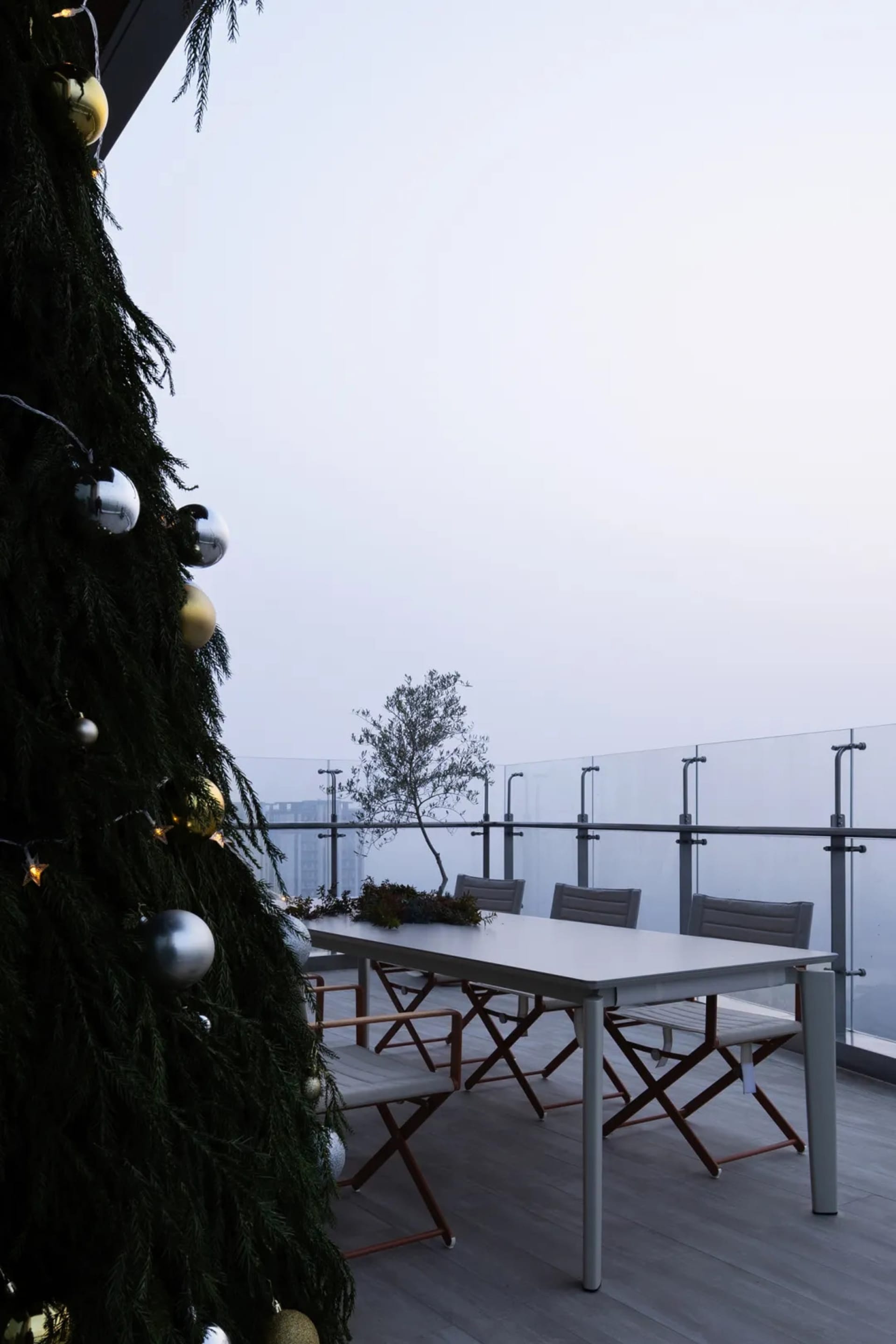 A well-decorated Christmas tree with a table setting in the background.