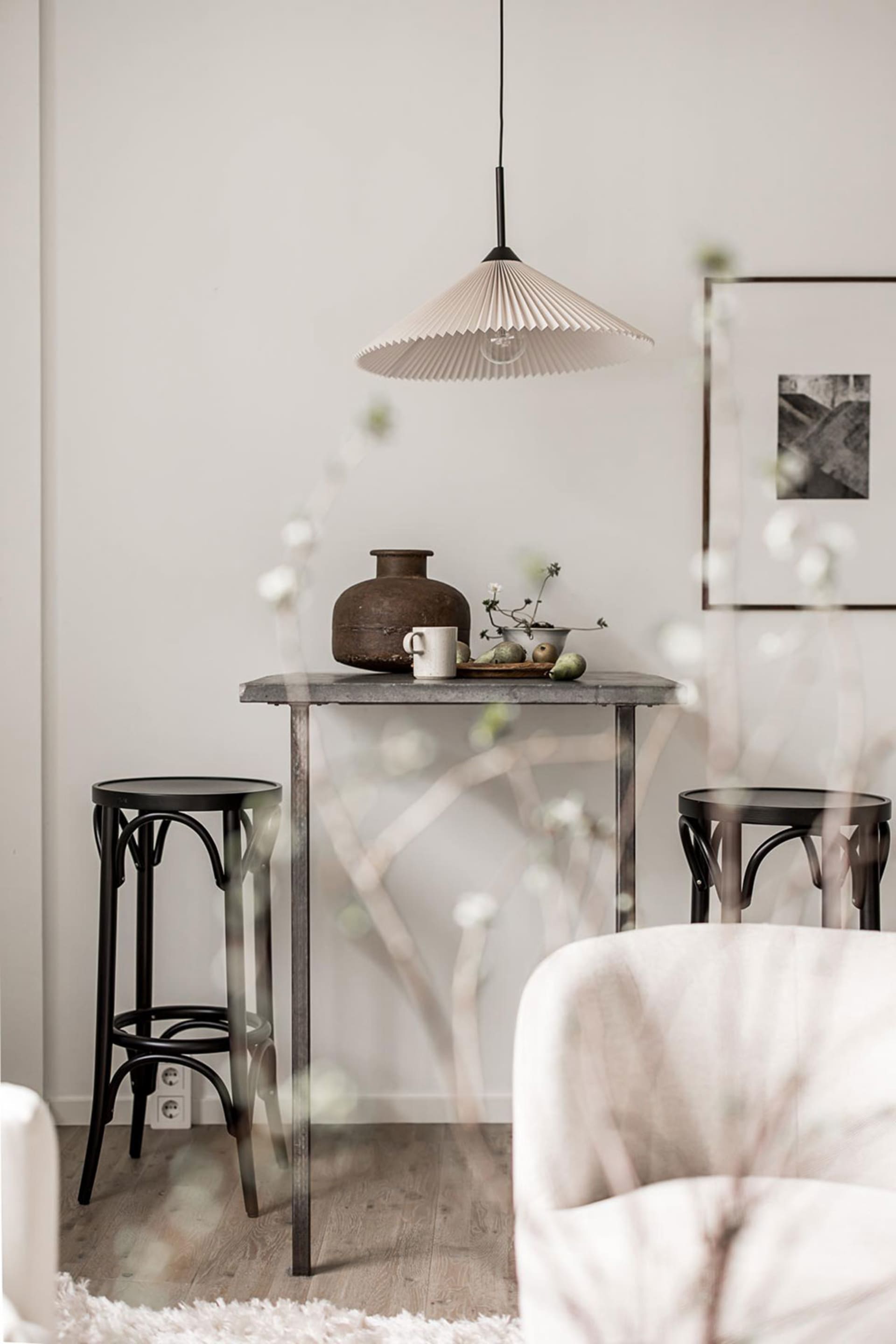 Minimalist Scandinavian living room with concrete table and wooden stools.
