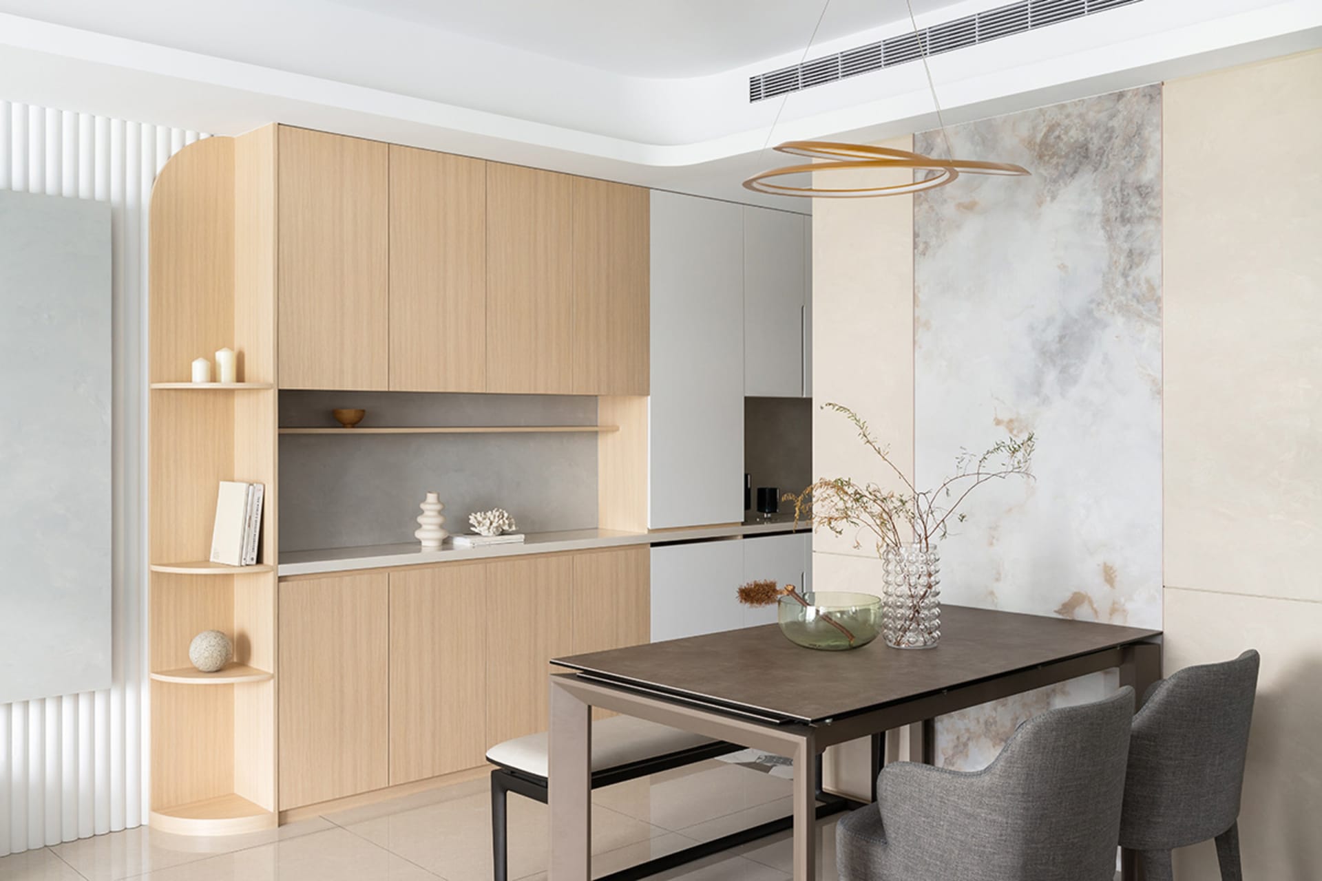 Modern kitchen dining room featuring wooden cabinets, concrete countertop, and marble accent wall.