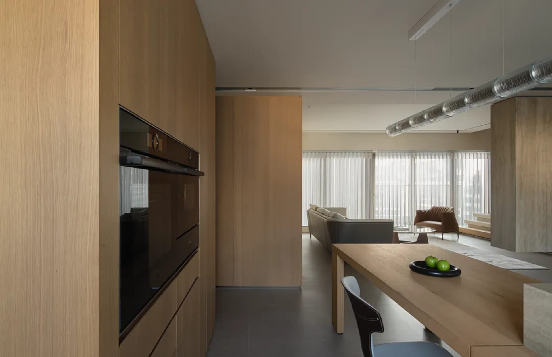 Modern kitchen with wooden cabinets, concrete flooring, and open-plan layout.