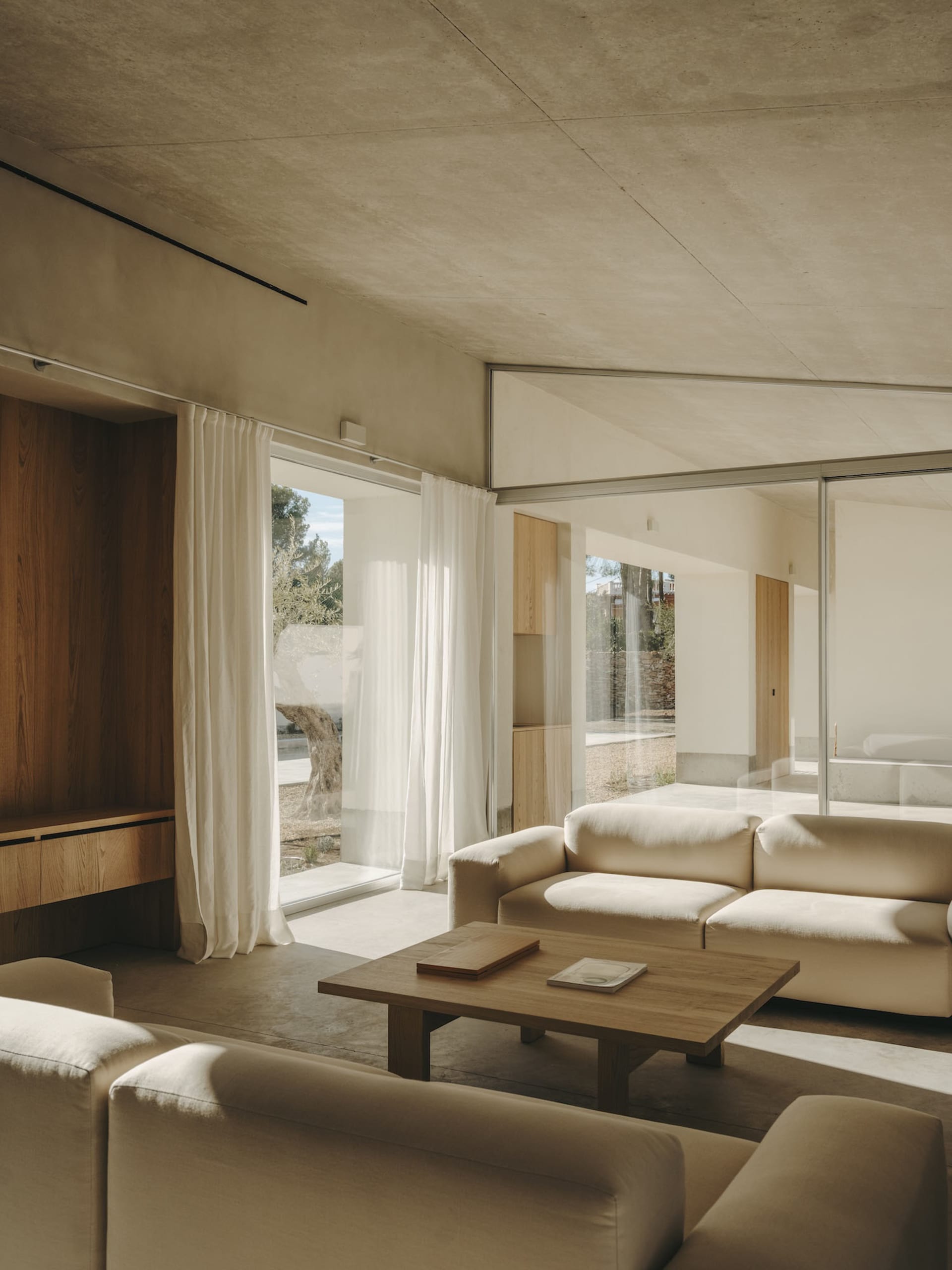 Modern minimalistic living room featuring light wood and concrete elements