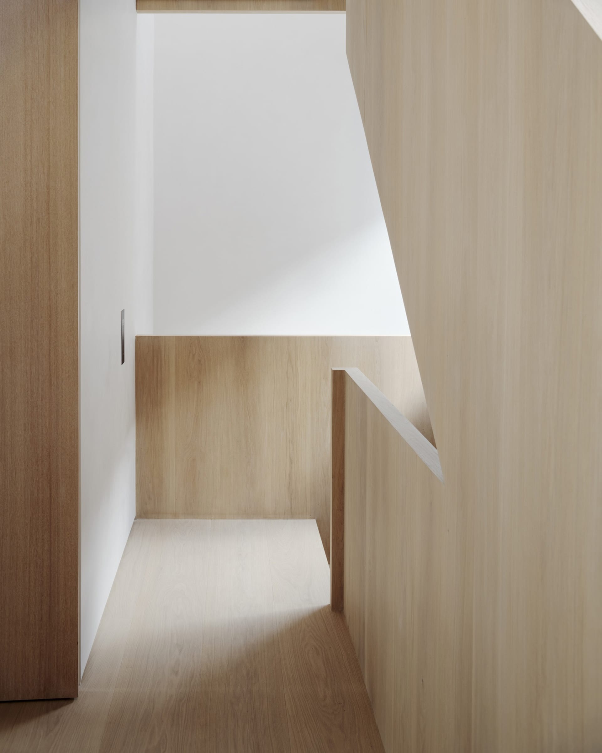 A modern interior design featuring wooden walls and floors, with a minimalist aesthetic.