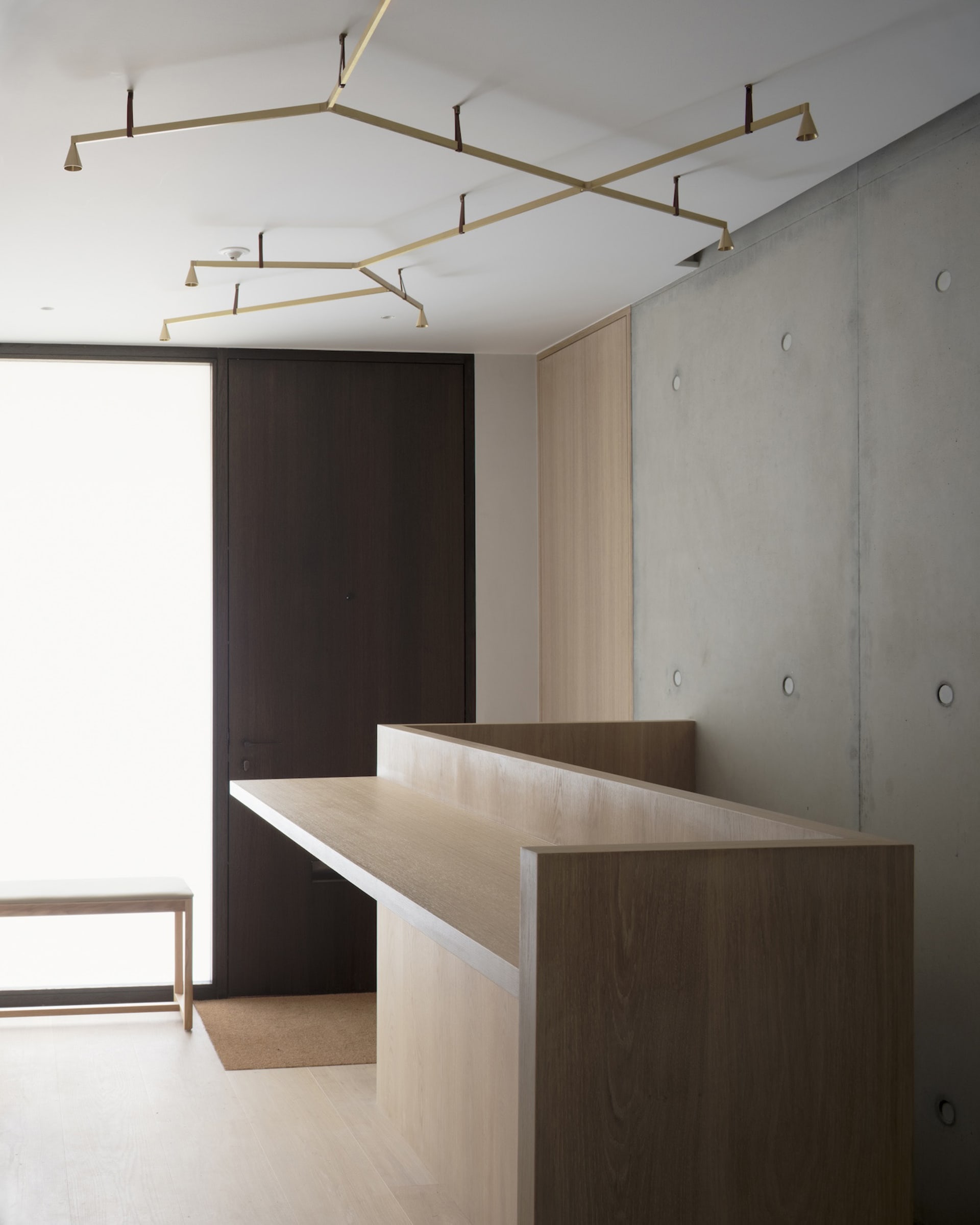 A modern office space featuring a wooden desk and minimalist design.