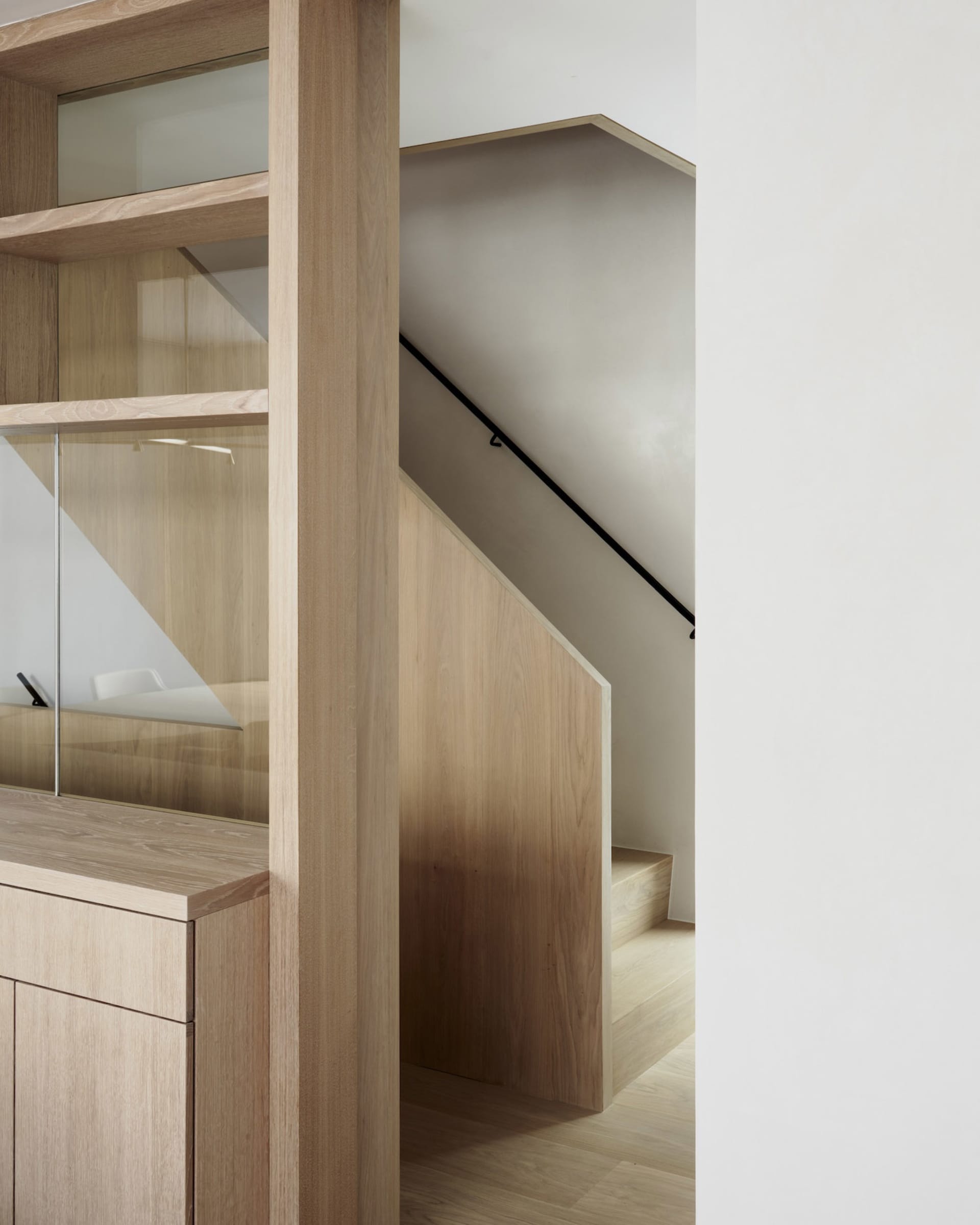 Modern wooden staircase within a minimalist interior design setting.
