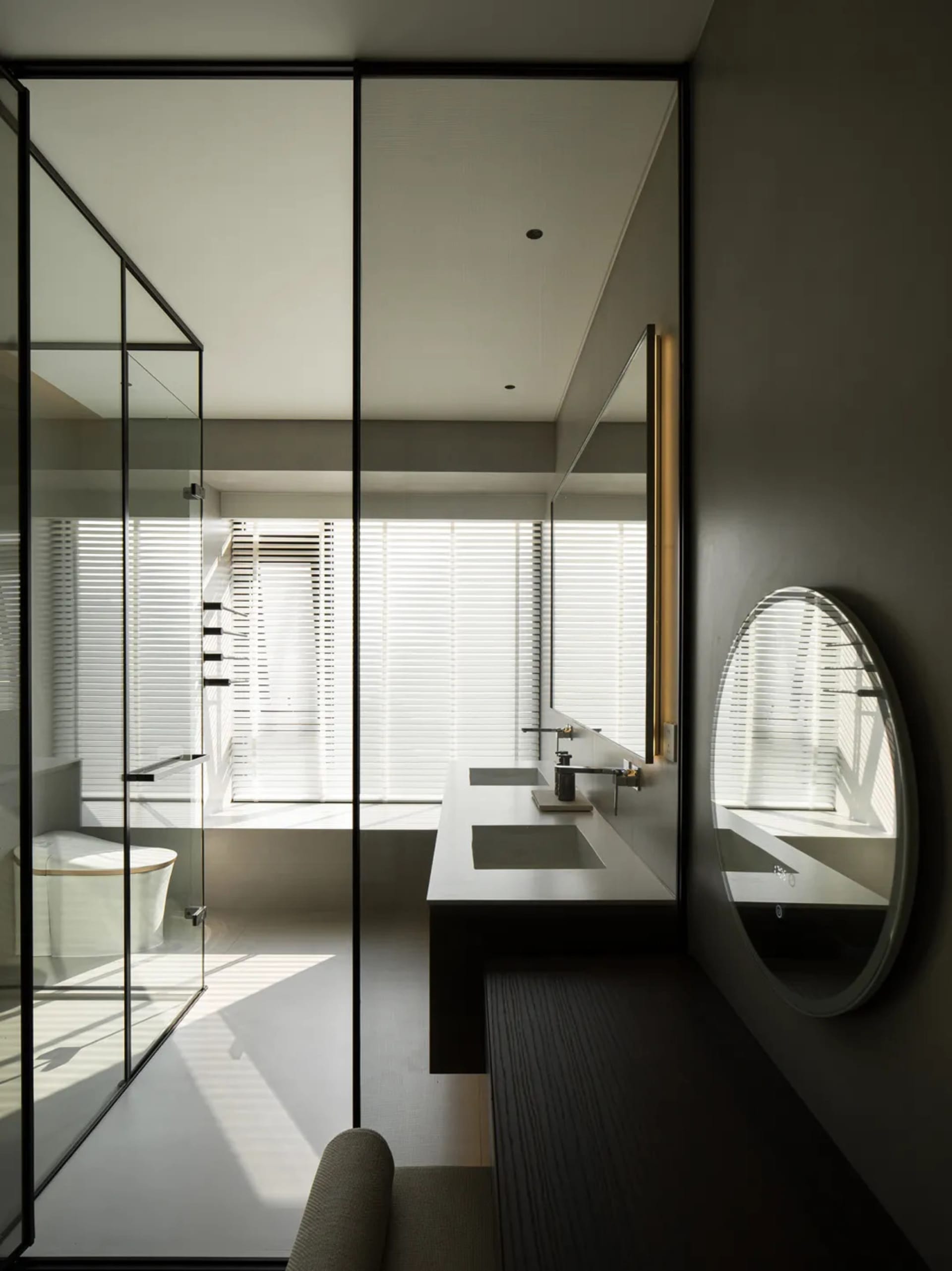 Modern minimalist bathroom featuring glass walls and white ceramic fixtures.
